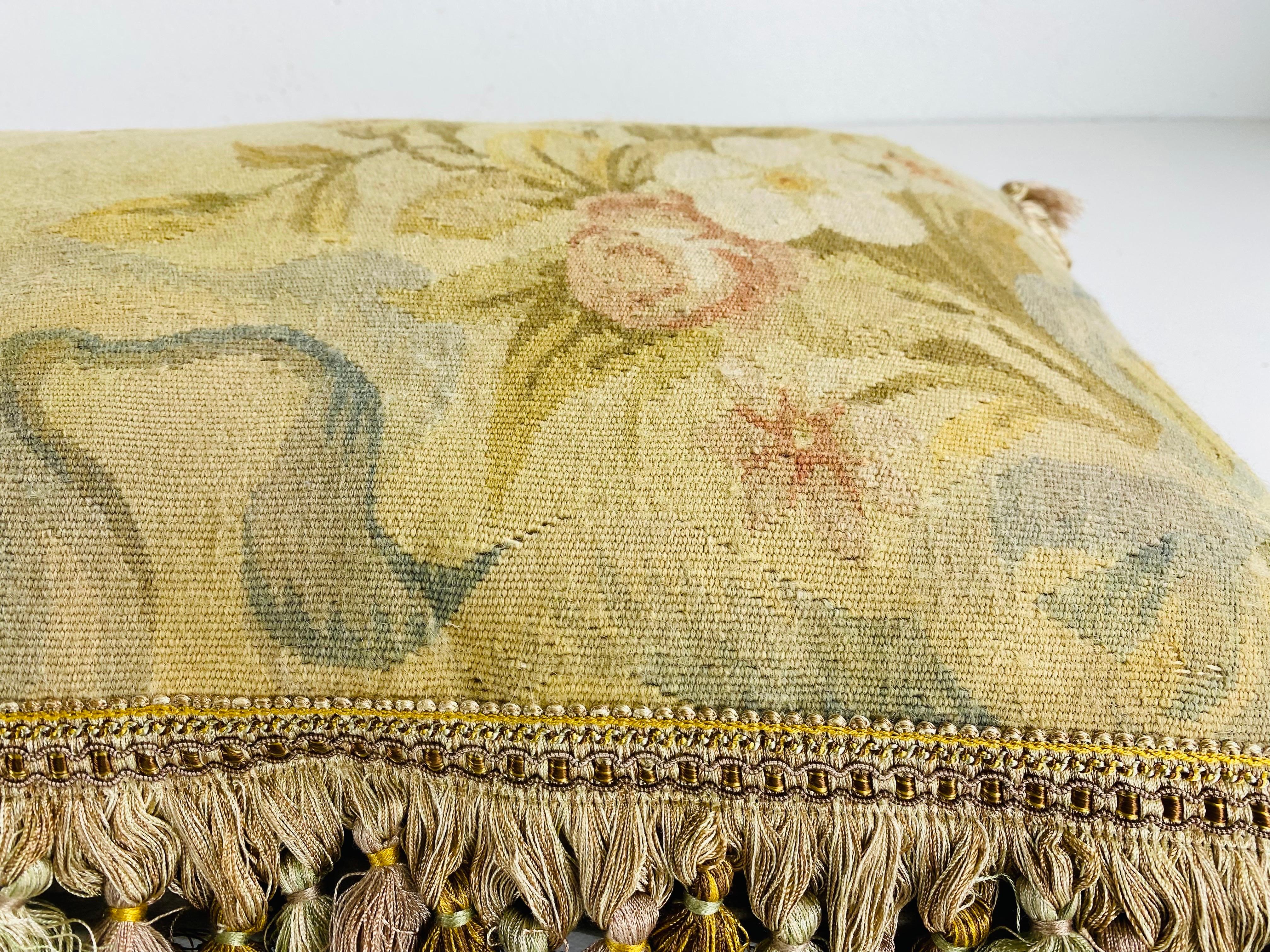 Questo è un cuscino vintage con nappe e arazzo Aubusson. Questo arazzo floreale presenta bellissimi toni di rosa, verde tenue e marrone. Lo scampolo di arazzo è stato trasformato in un cuscino con una frangia di nappe coordinata e con il retro in