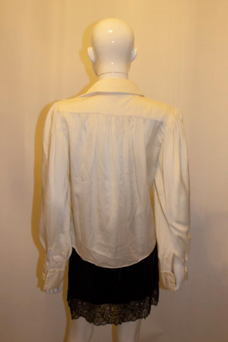 Ein hübsches Vintage-Seidenhemd von Tatters (berühmtes Geschäft in London). Die Seide ist superweich und das Hemd / die Bluse hat stoffbezogene Knöpfe,  doppelte Manschetten und Raffungen an den Schultern.
Maße: Büste 37'', Länge 22''