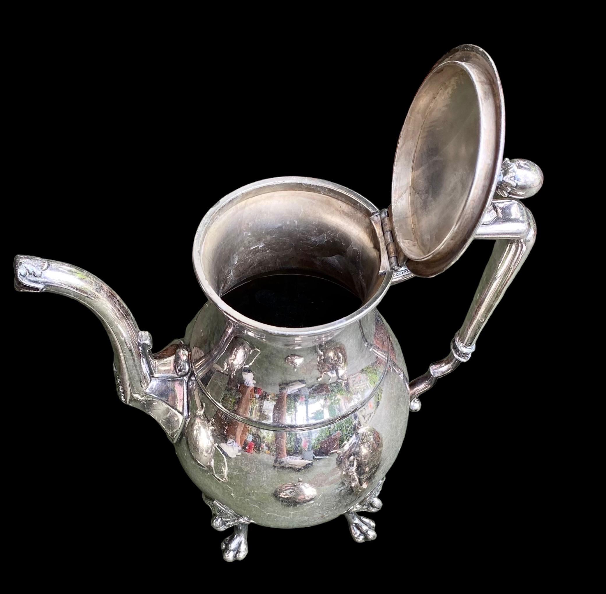 Vintage Taunton quadruple silver plated, Art Deco tea pot, sugar bowl and creamer, having hoof feet with Art Deco masks, the lids with egg shaped finials resting on tripod paw feet and beautiful geometric handles with beading and small finials c