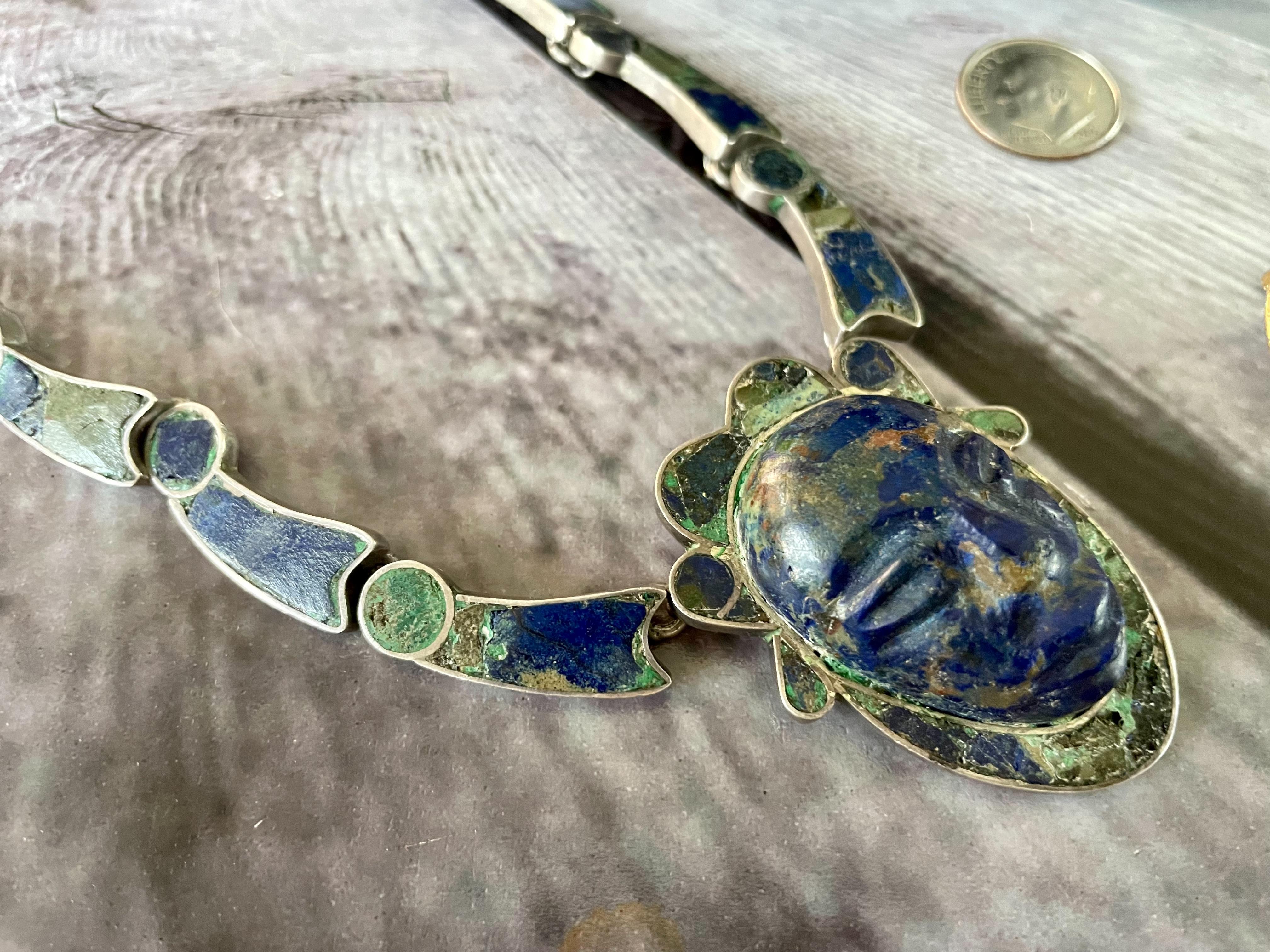 This vintage Taxco Necklace features inlay stone (perhaps Lapis and Turquoise) on a Sterling Silver necklace and pendant.  

The pendant resembles the head of a warrior!

Stamped: TAXCO 975 STERLING

Dimensions:
Chain 17