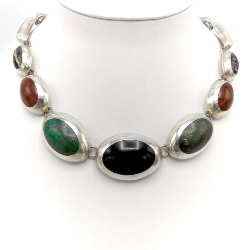 This is a stunning Taxco sterling silver necklace featuring onyx, jasper, turquoise and another unidentified polished black striped stone. This piece is in the style of Enrique Ledesma. The silver is impeccably blended with the stones. Clearly, with