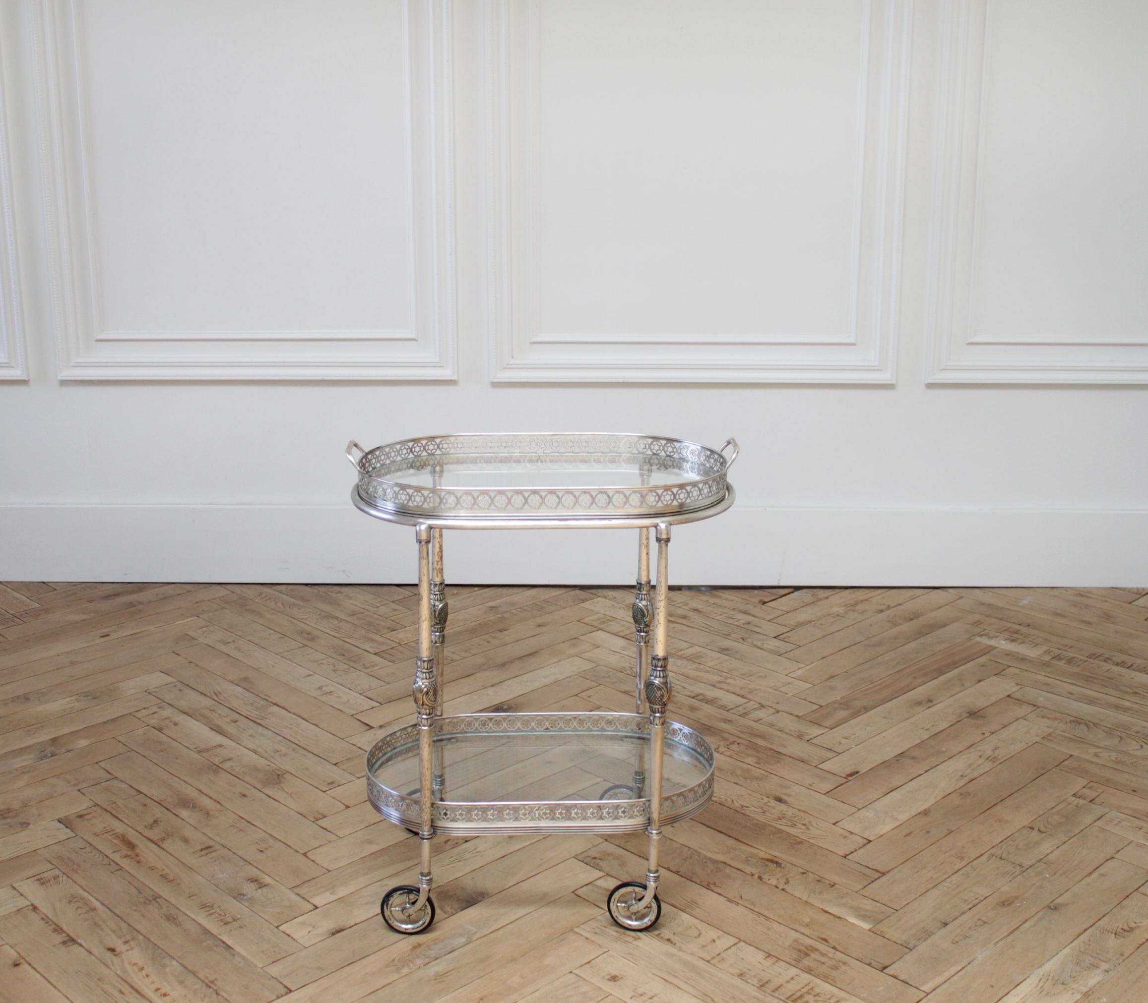 Vintage tea cart serving tray in silver finish
Petite bar cart in a silver finish, with rubber wheels. The top is a tray that can lift off to take and use to serve with.
Glass top and bottom shelf, is removable.
Measures: 21