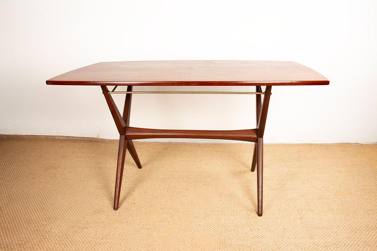 A rare and ingenious table that can be used as a dining table or a large coffee table. A clever tubular metal mechanism allows for easy height adjustment. With its double X-shaped legs connected by a stretcher and its slightly oblong top, it boasts