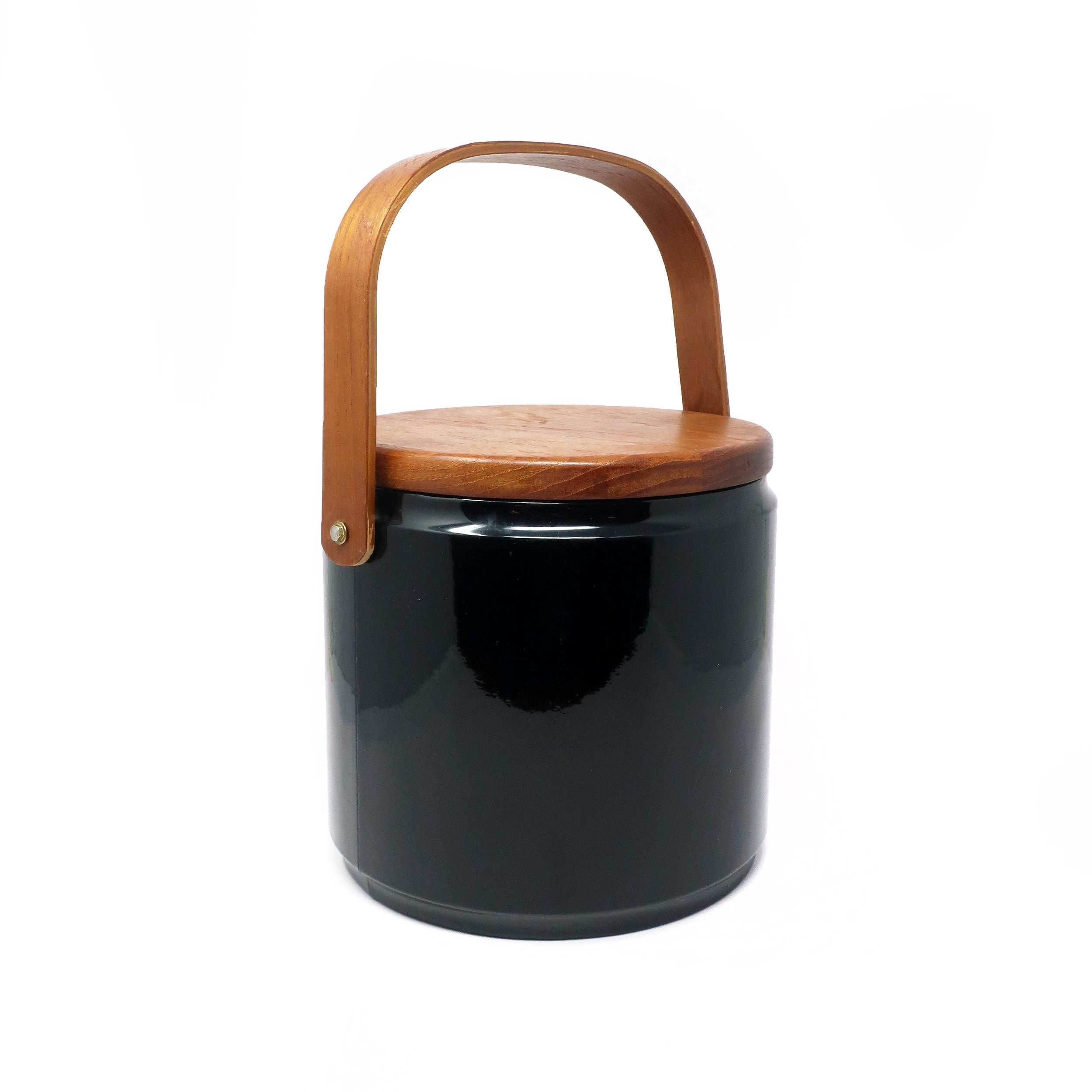 A vintage Mid-Century Modern ice bucket by Georges Briard from the 1960s/1970s with a teak handle and lid on a plastic covered bucket. In good vintage condition with few signs of use, including a slight curve to the handle. Signed on underside of