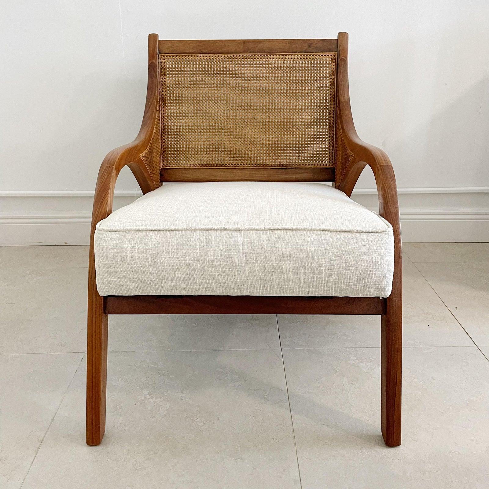 Pair of lounge chairs in teak wood with cane inserts on sides and back. Newly upholstered in off white fabric.