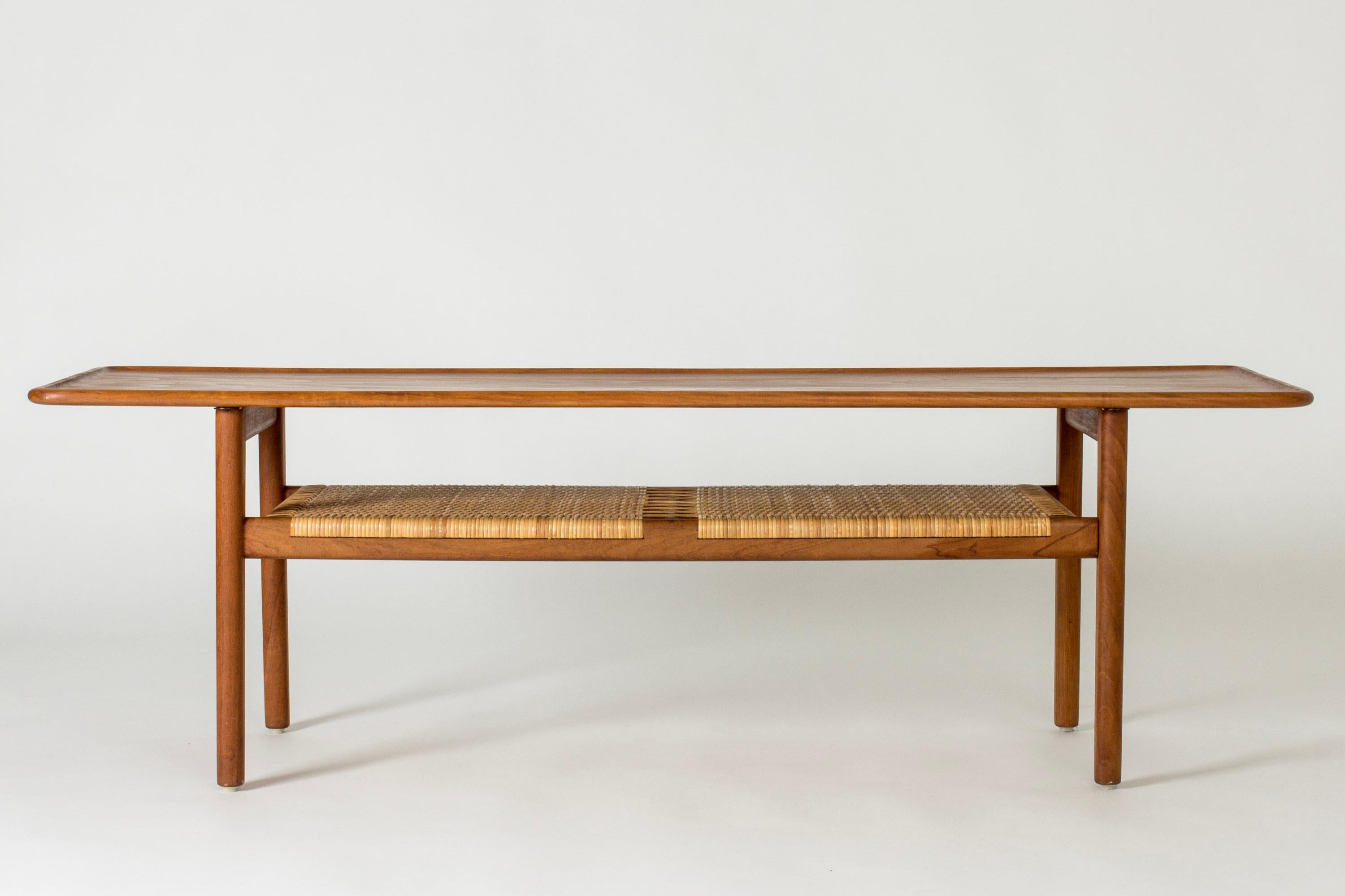 Beautiful teak coffee table with a rattan shelf by Hans J. Wegner, model “AT10”. The warm teak nuance contrasts nicely with the blonde rattan.