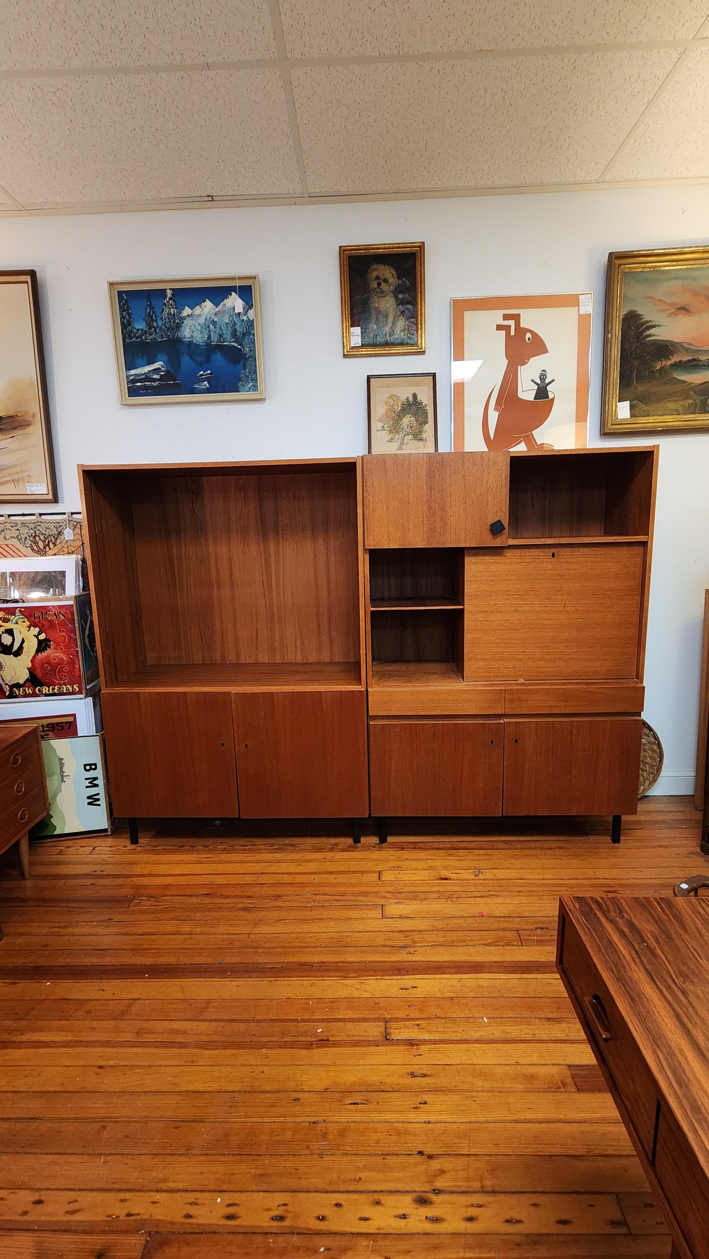 This pair of teak office pieces include a Bookshelf with lower cabinet and the second unit has storage area plus a tilt-down desk which would also work well as a bar. 
This set was purchased from the original owner and is in good original condition.