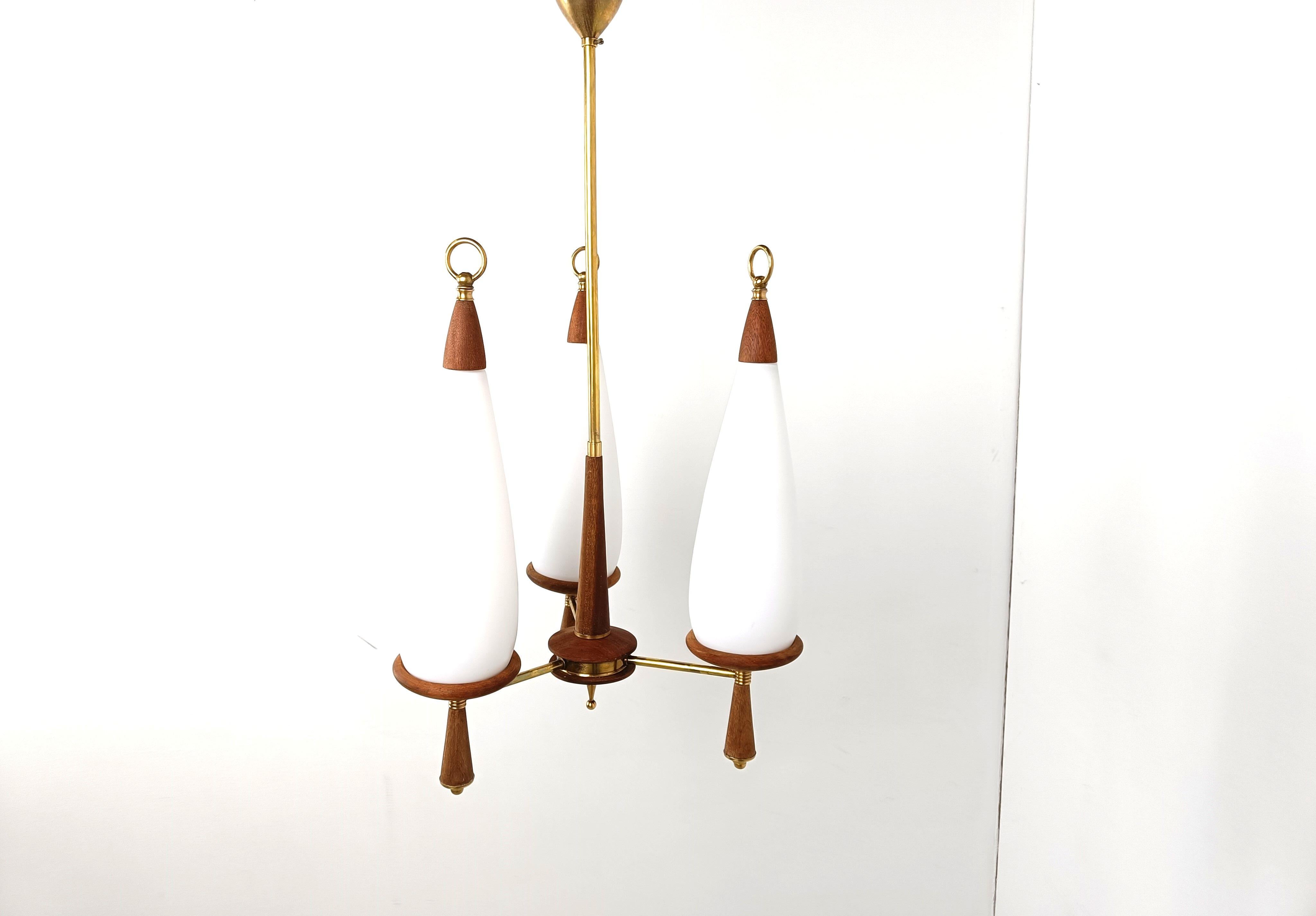 Mid century scandinavian chandelier made of teak with  teardrop shaped milk glass shades.

The teak chandelier is in perfect condition and has the original brass ceiling canopy.

It creates a warm and charming atmosphere.

Tested and ready for