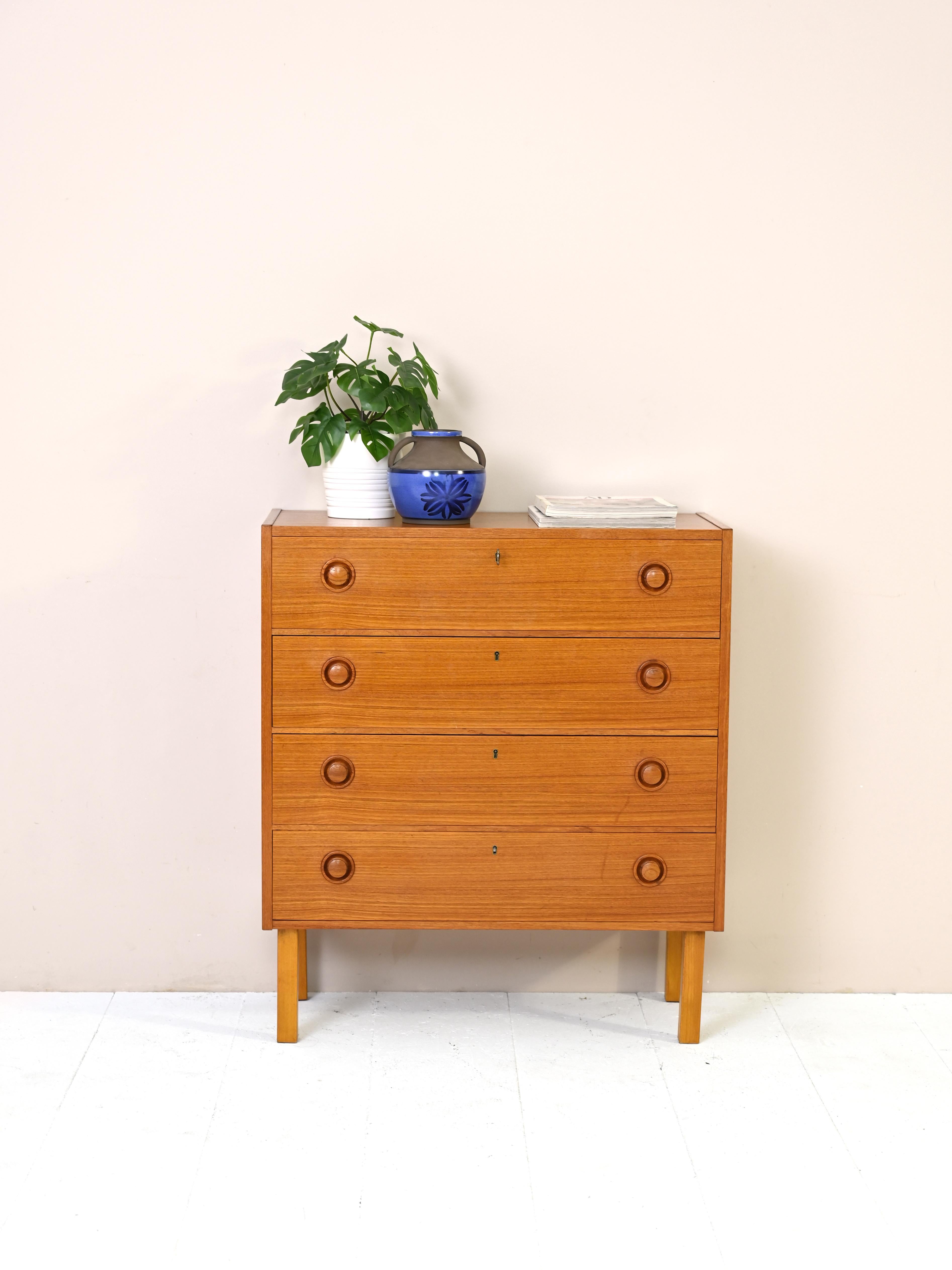 Scandinavian cabinet with 4 lockable drawers.
A modern piece characterized by square lines in the amber color of teak wood.
The round handle of the drawers embellishes the structure.
Good condition. A conservative restoration with products of
