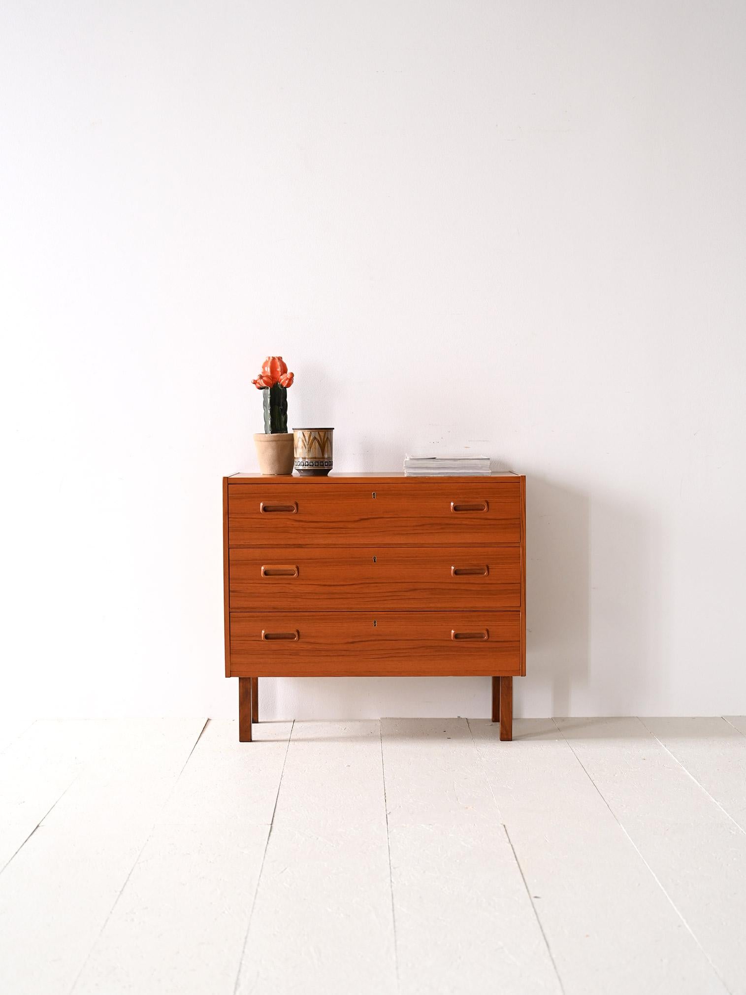 Skandinavische Vintage-Möbel aus den 1960er Jahren.

Diese Kommode mit quadratischen, minimalen Linien verfügt über drei abschließbare Schubladen mit einem geschnitzten Holzgriff. 
Ein einzigartiges Möbelstück, das dank seines modernen Designs ideal