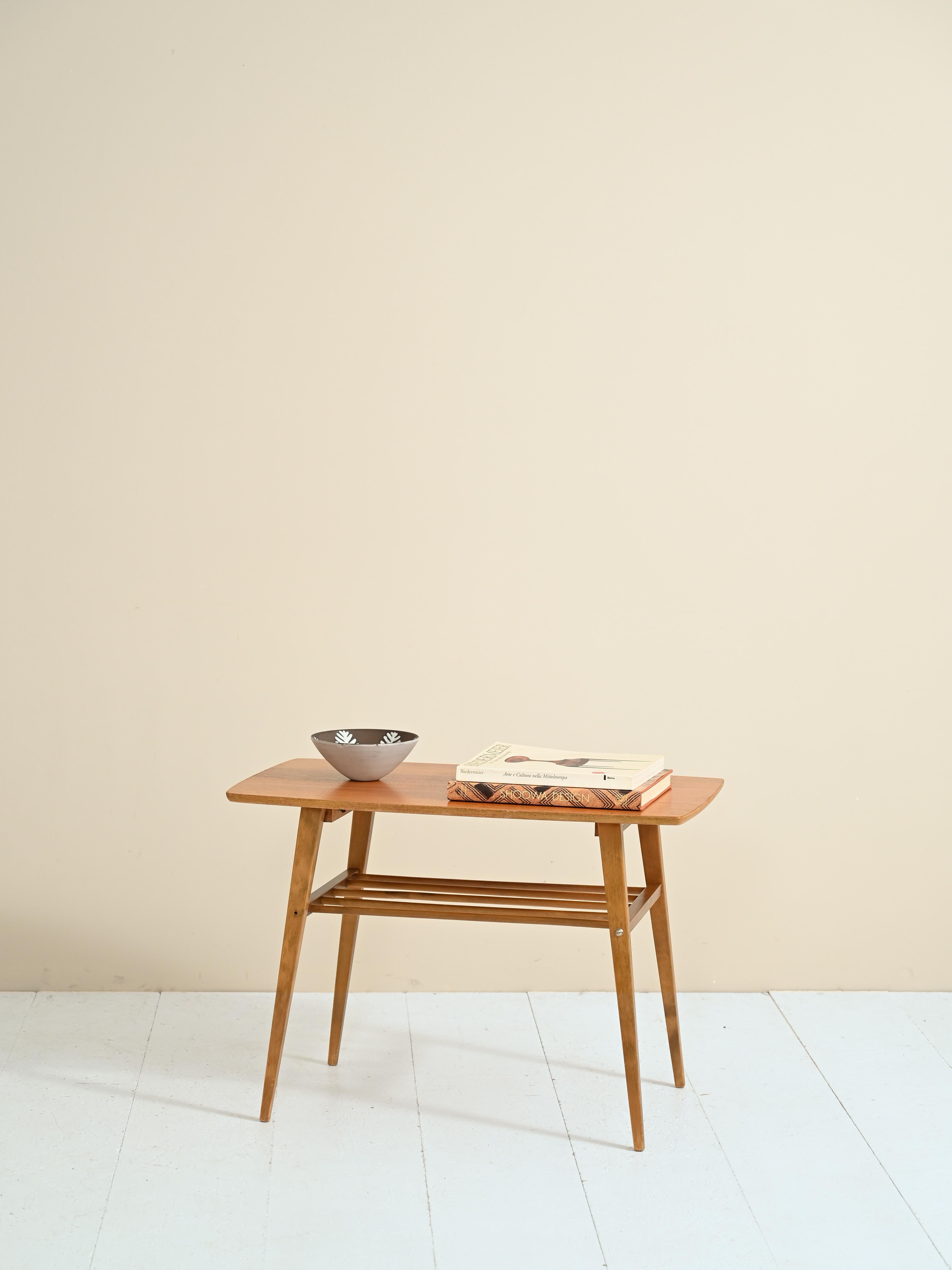 Vintage coffee table with magazine shelf.
The clean, minimal lines trace the Nordic tradition of combining aesthetics and functionality.
This small-sized coffee table can be used as a bedside table and thanks to the
presence of a second shelf, it is