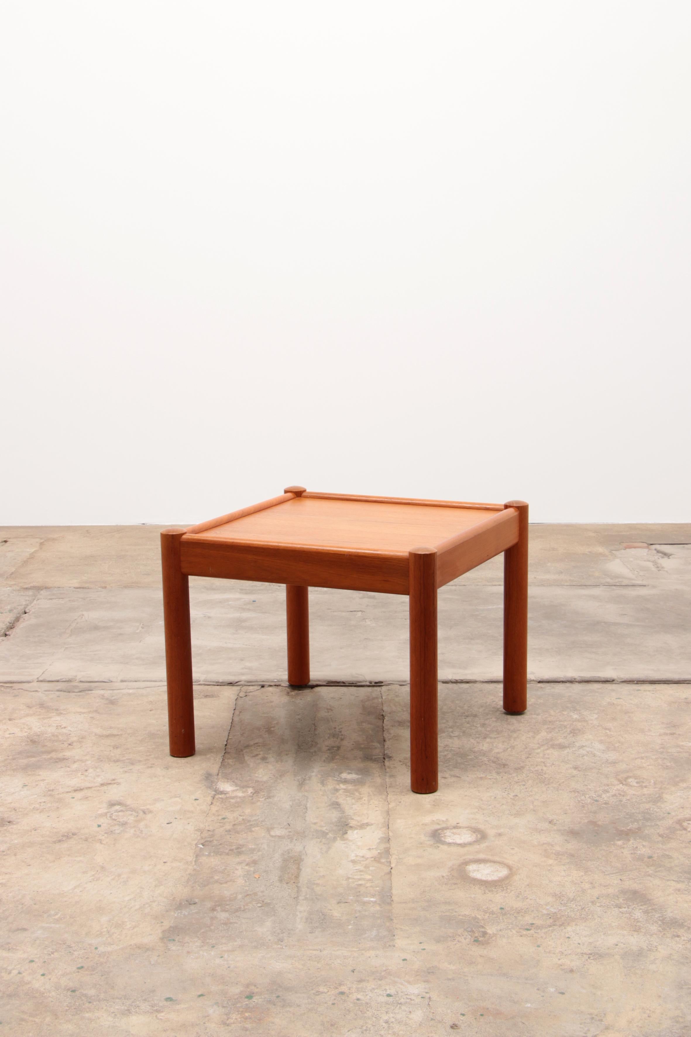 Discover the charm of mid-century design with this exquisite vintage coffee table, crafted from solid teak in 1960s Denmark. This square table features a thick tabletop with elegantly rounded edges and unique notches where the round support legs are