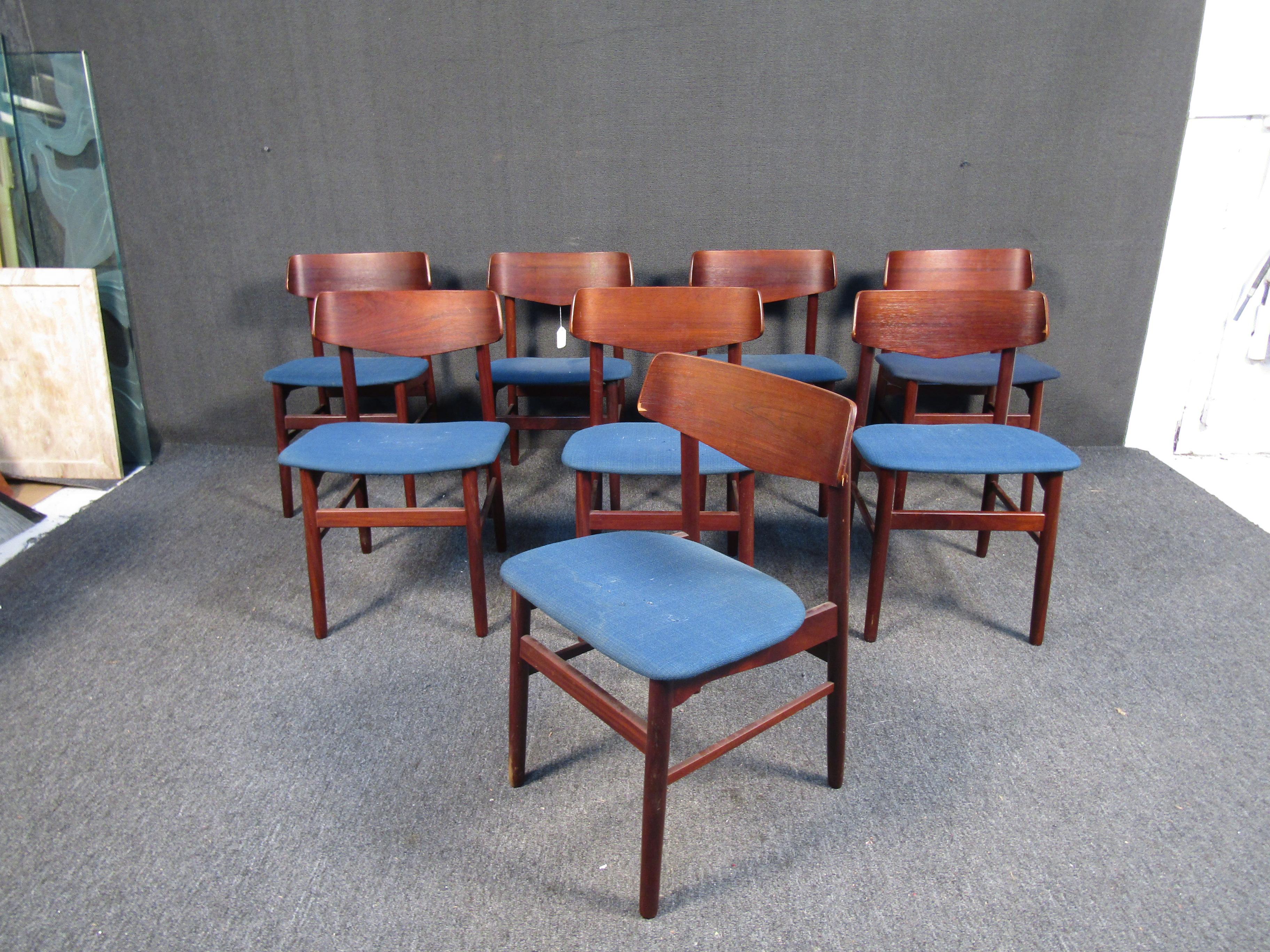 Stylish set of 8 Danish modern style dining chairs. These chairs feature contoured backrests with tapered legs and blue upholstered seats. These chairs would make a great addition to any modern interior's decor. 

Please confirm item location with