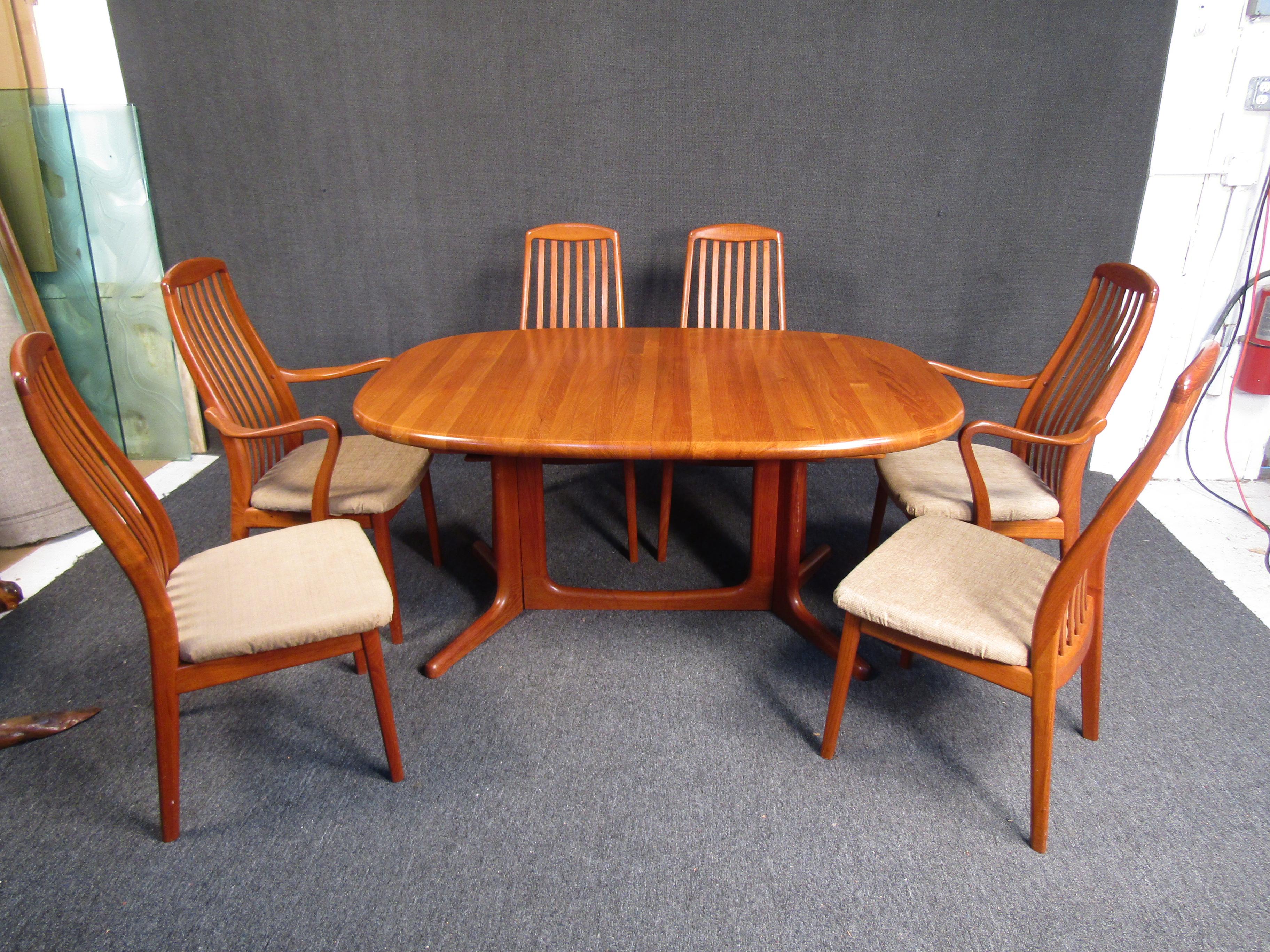 Full of Mid-Century Modern elegance, this vintage dining set by Glostrup combines understated design with craftsmanship and rich teak wood. The table can extend with two leaves, making this set a versatile addition to any home. Please confirm item
