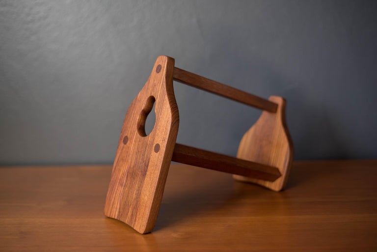 Mid-Century Modern wine bottle holder designed by Jens H. Quistgaard for Dansk, Denmark. This unique piece is made of solid teak with dowel joint inlays. Equipped with a carrying handle and perfect for displaying at a table setting or home