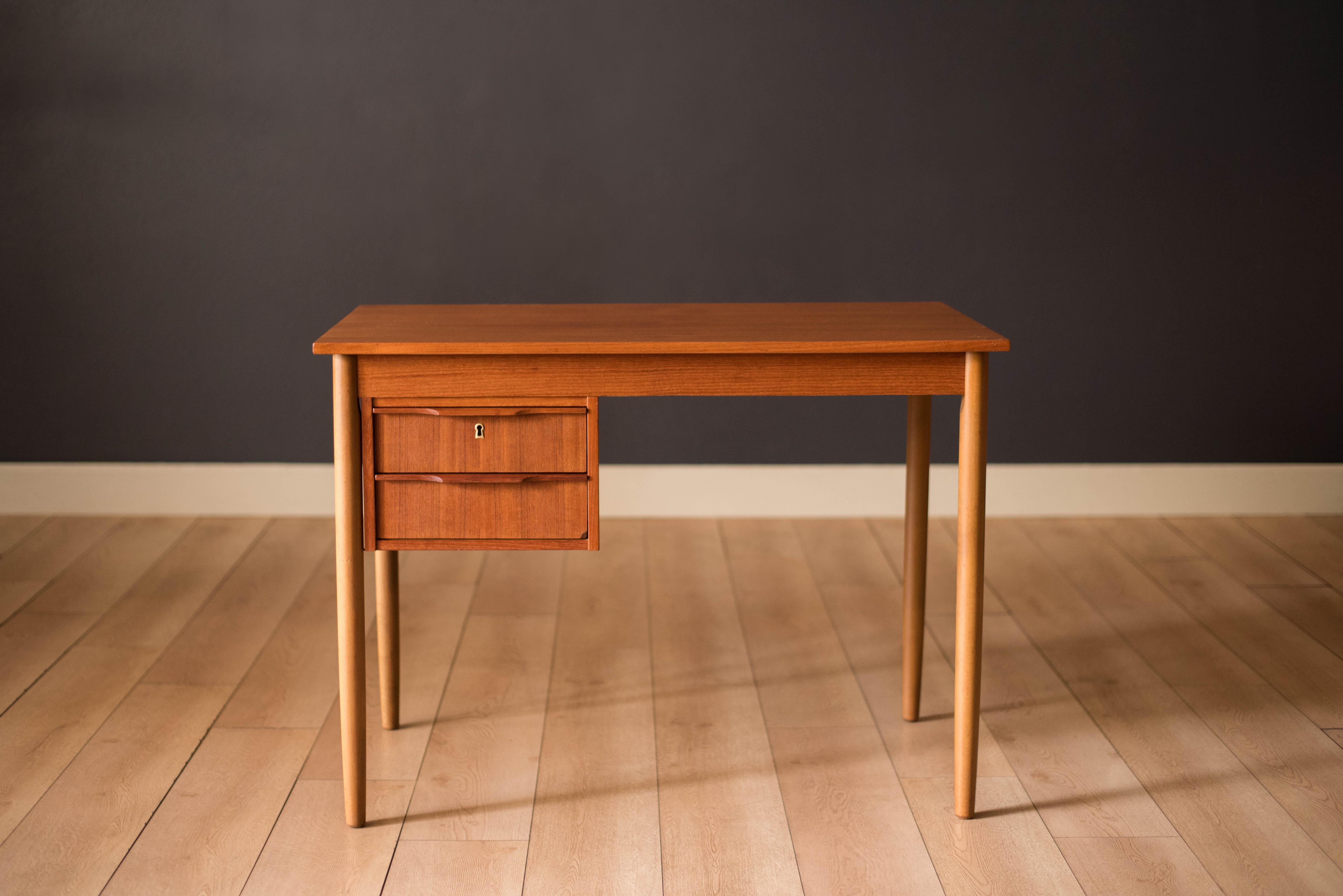 Mid-Century Modern compact writing desk in teak and birch manufactured by Ejsing Møbelfabrik, Denmark. This contrasting piece includes two dovetailed drawers with sculpted handles and tapered pencil legs. The perfect fit for small spaces and can be