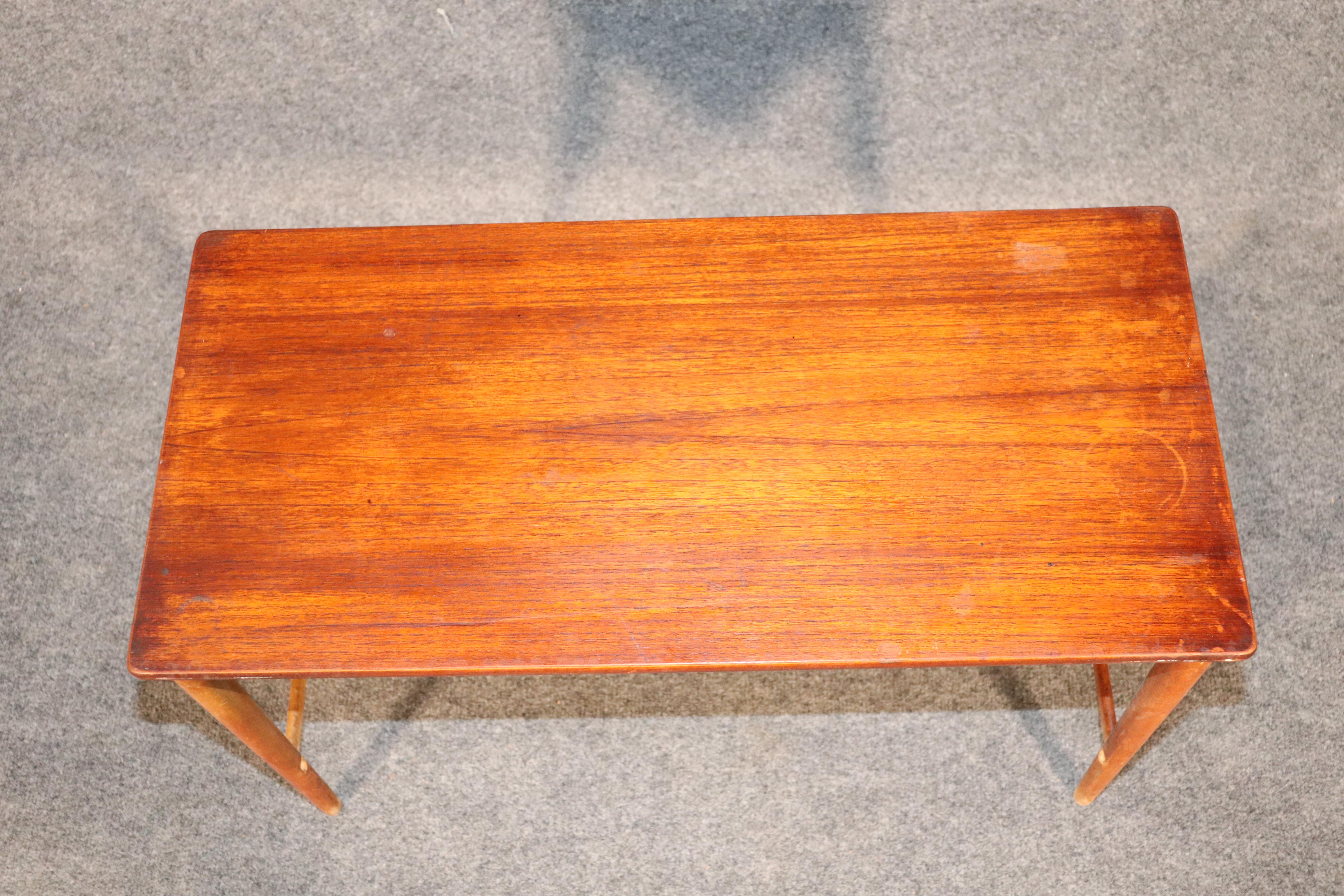 Mid-Century Modern Danish table in teak wood. Slender legs and wood runners with warm teak top.
Please confirm location.
 