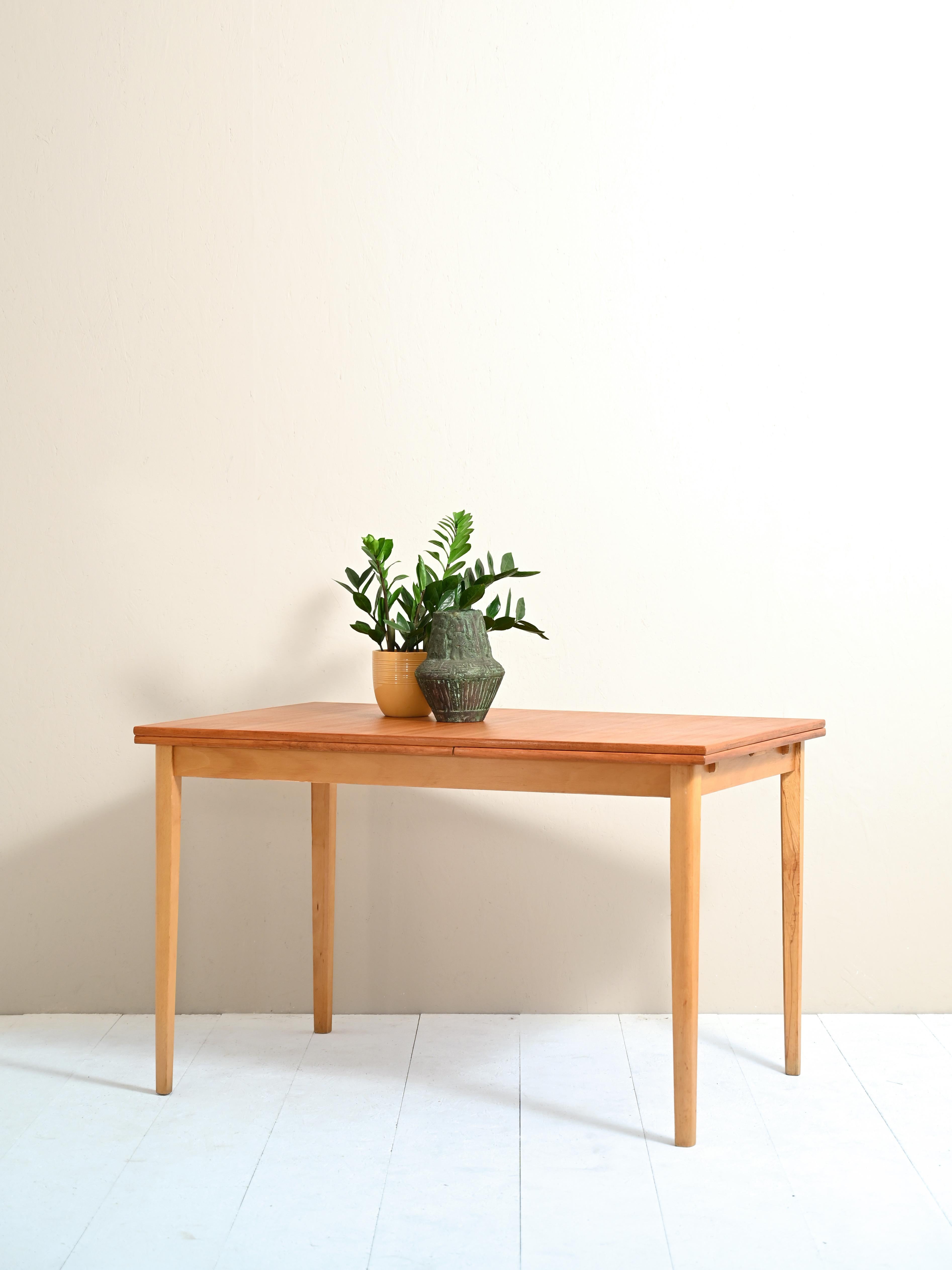 Scandinavian table made of original teak from the 1950s/60s.
The shape is rectangular and is perfect for four people. Thanks to the 50cm long pull-out extension, the table can comfortably seat six people.
The extension leaf measures 50cm.

Good
