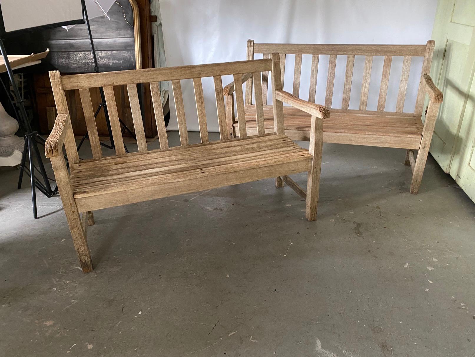 Classic styling, vintage two-seat teak bench with arms has wonderful weathered patina. Wonderful for the patio, porch or garden.