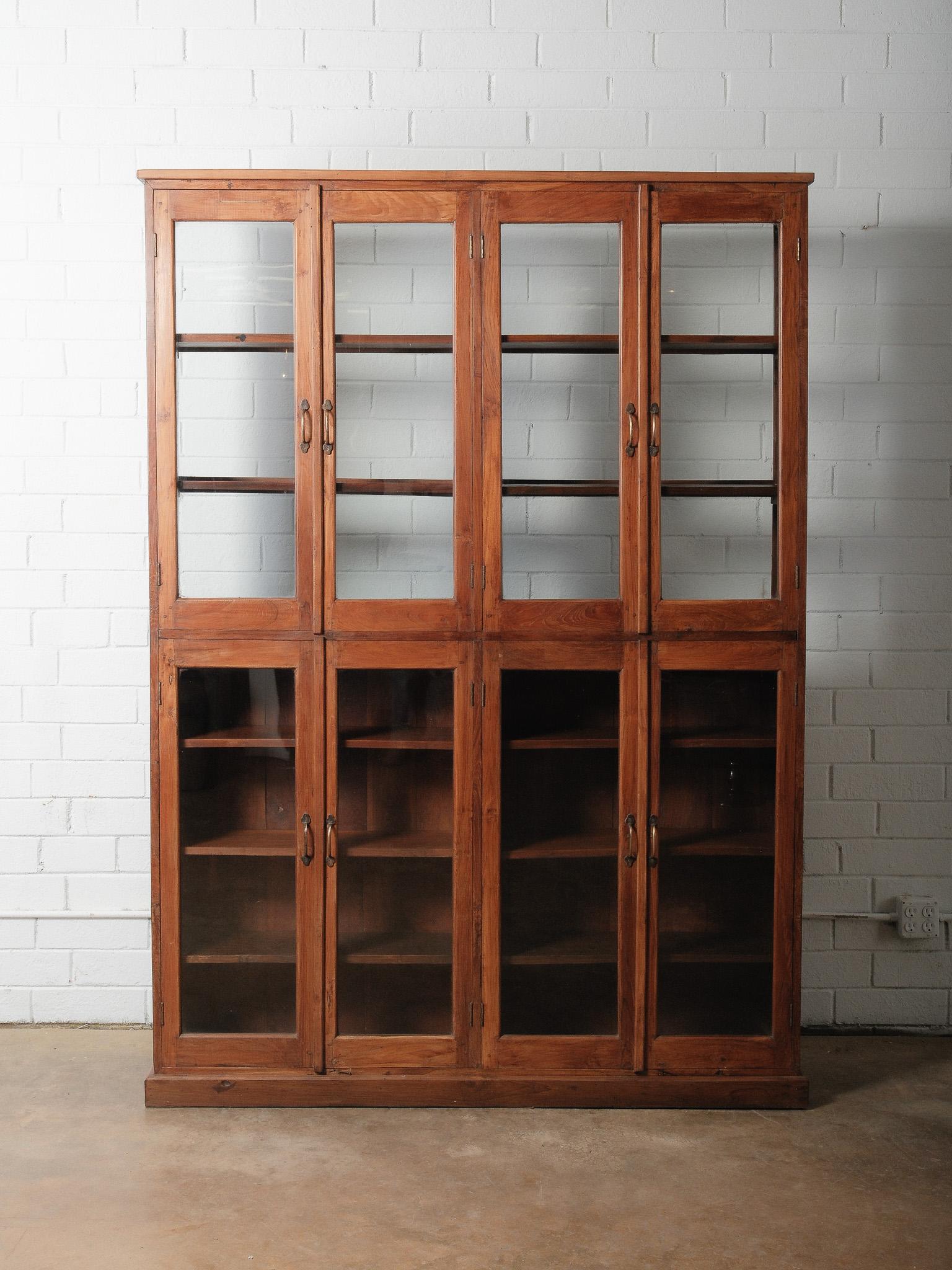 Un'imponente vetrina vintage in teak con otto ante rivestite in vetro e un design pulito e senza tempo. Realizzato con una calda finitura in legno naturale, questo mobile alto offre sia un'archiviazione funzionale che un'elegante possibilità di