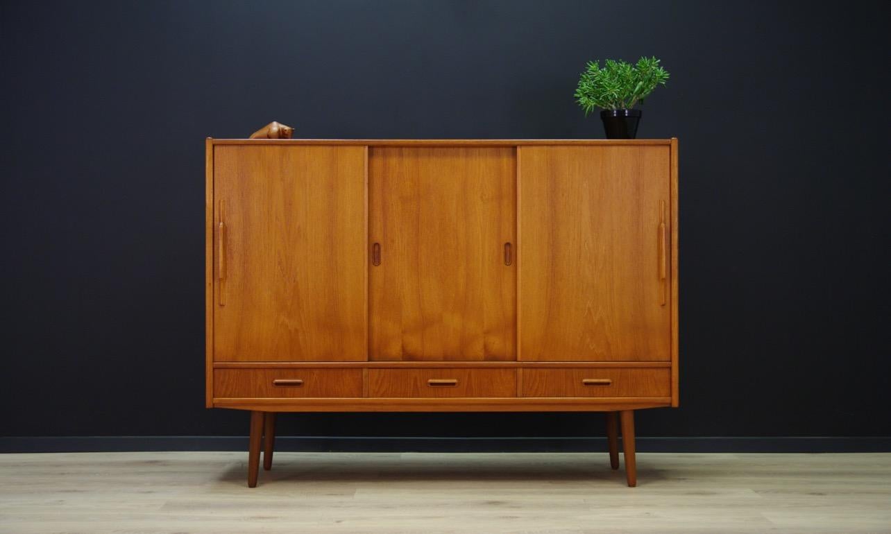 Phenomenal highboard from the turn of the 1960s-1970s. A brilliant form - Danish design. Furniture veneered with teak. Spacious interior with numerous shelves and drawers behind the sliding doors. Three spacious drawers. Preserved in good condition