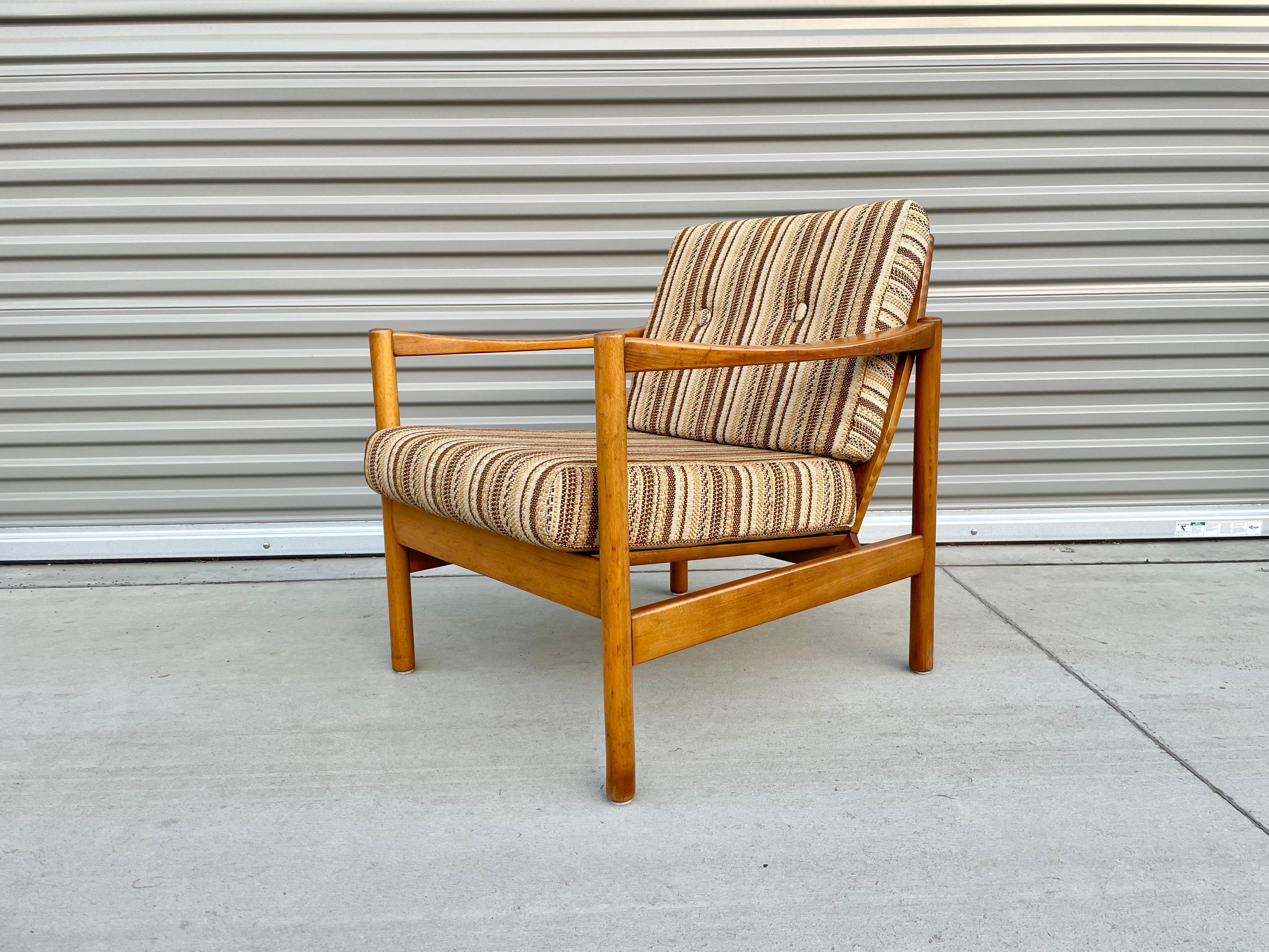 Beautiful midcentury teak lounge chair designed and manufactured in Denmark, circa 1960s. This vintage lounge chair features a unique curve armrest giving it a great distinctive design for its era. The chair also offers excellent lumbar support