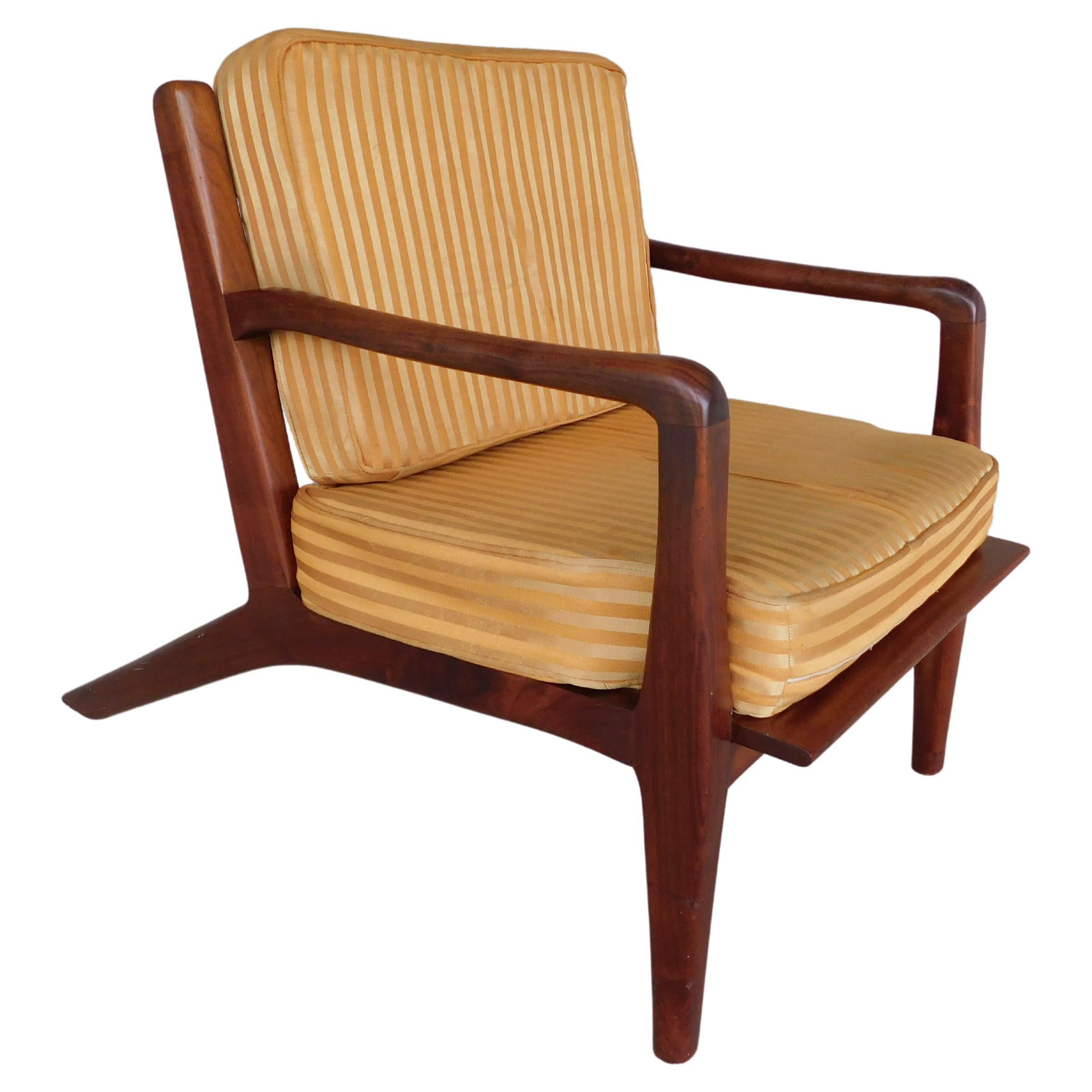 Vintage teak midcentury lounge chair attributed to Hans Wegner. Unsigned chair with unique teak handcrafted style. Horizontal back support slats, slightly slung arm design with rolled over hand rest. Long raked rear legs adding to the stance.