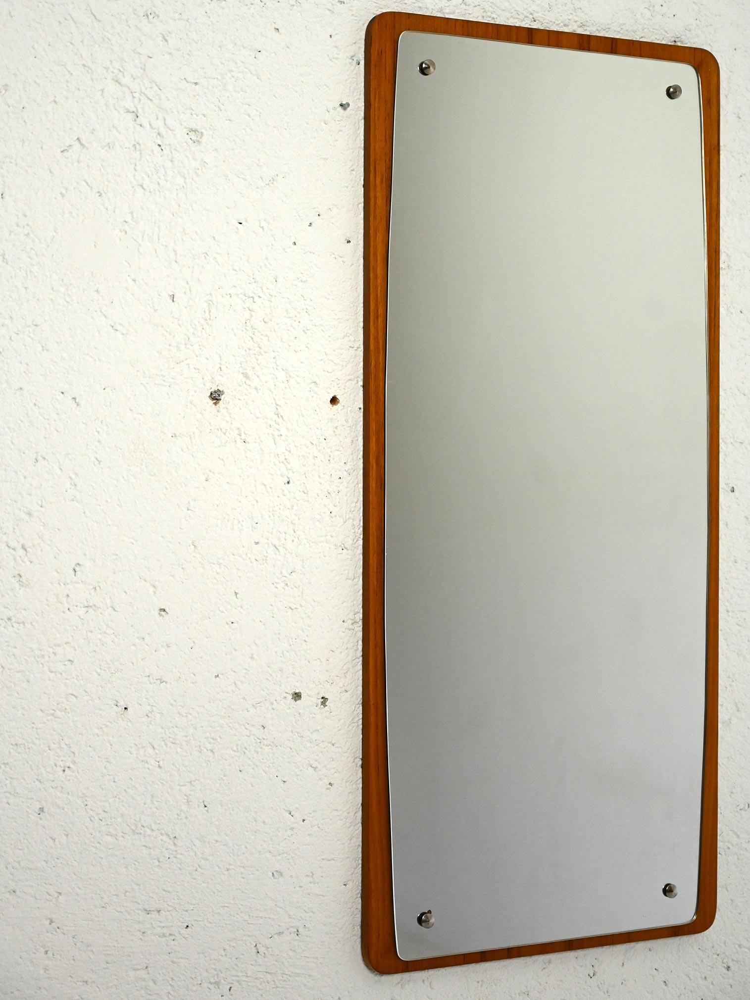 Scandinavian 1960s mirror.

A mirror with small dimensions, characterized by a slight curvature at the sides that gives it a unique and elegant touch. The frame is made of teak wood, following the typical style of the 1960s, it presents a linear and