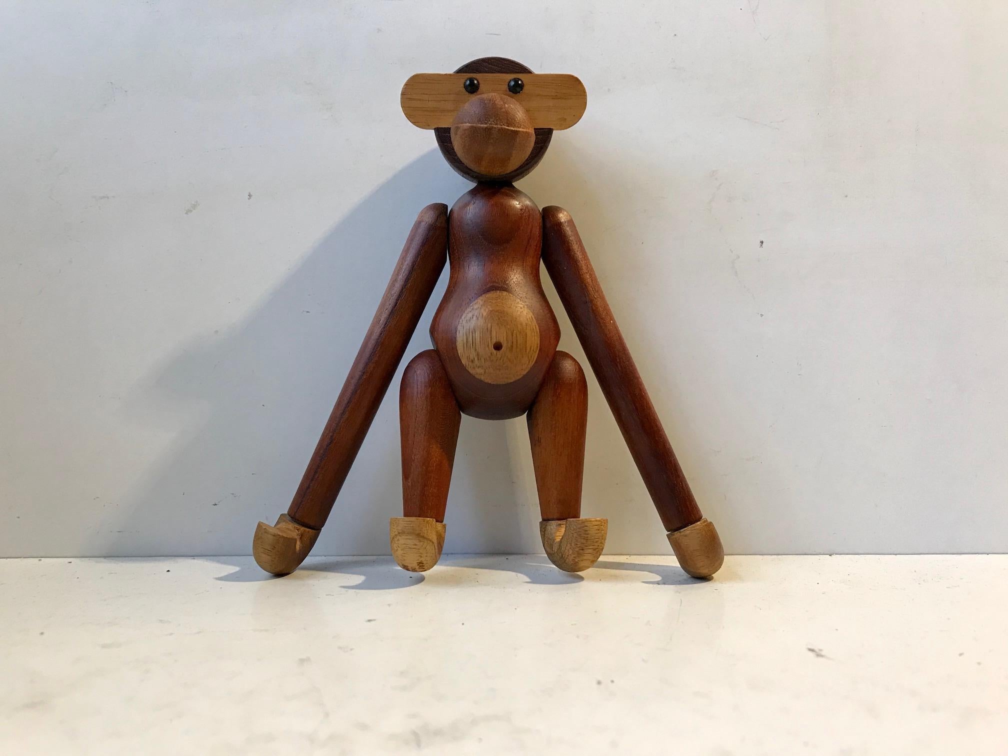 Wooden monkey designed by Kay Bojesen in 1951. Its made from solid teak and limba wood. It features articulated limbs, movable heads, arms and legs. This example was manufactured in Denmark during the 1970s.