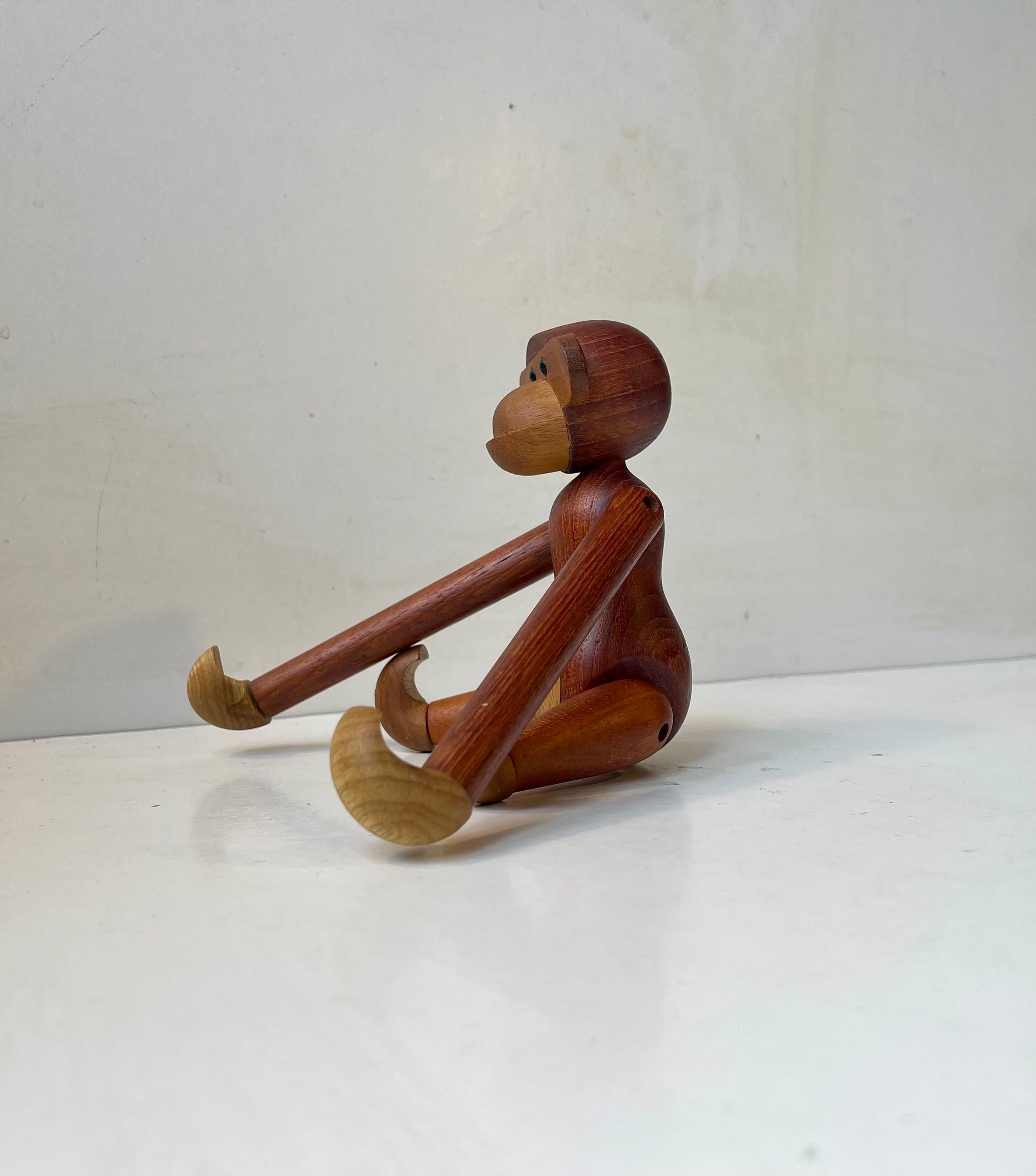 Holzaffe, entworfen von Kay Bojesen im Jahr 1951. Er ist aus massivem Teak- und Limba-Holz gefertigt. Sie hat bewegliche Gliedmaßen, einen beweglichen Kopf, Arme und Beine. Dieses Exemplar wurde in den 1970er Jahren in Dänemark hergestellt. Unter