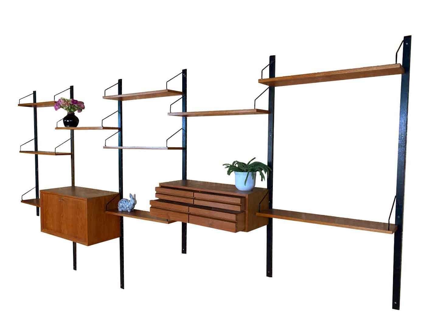 5 piece vintage wall system designed in 1948 by the Danish designer Poul Cadovius. The royal system has been brought at Cado Denmark. The wall system is made in teak and consists of a chair with 4 drawers, a storage cabinet with valve and shelves.