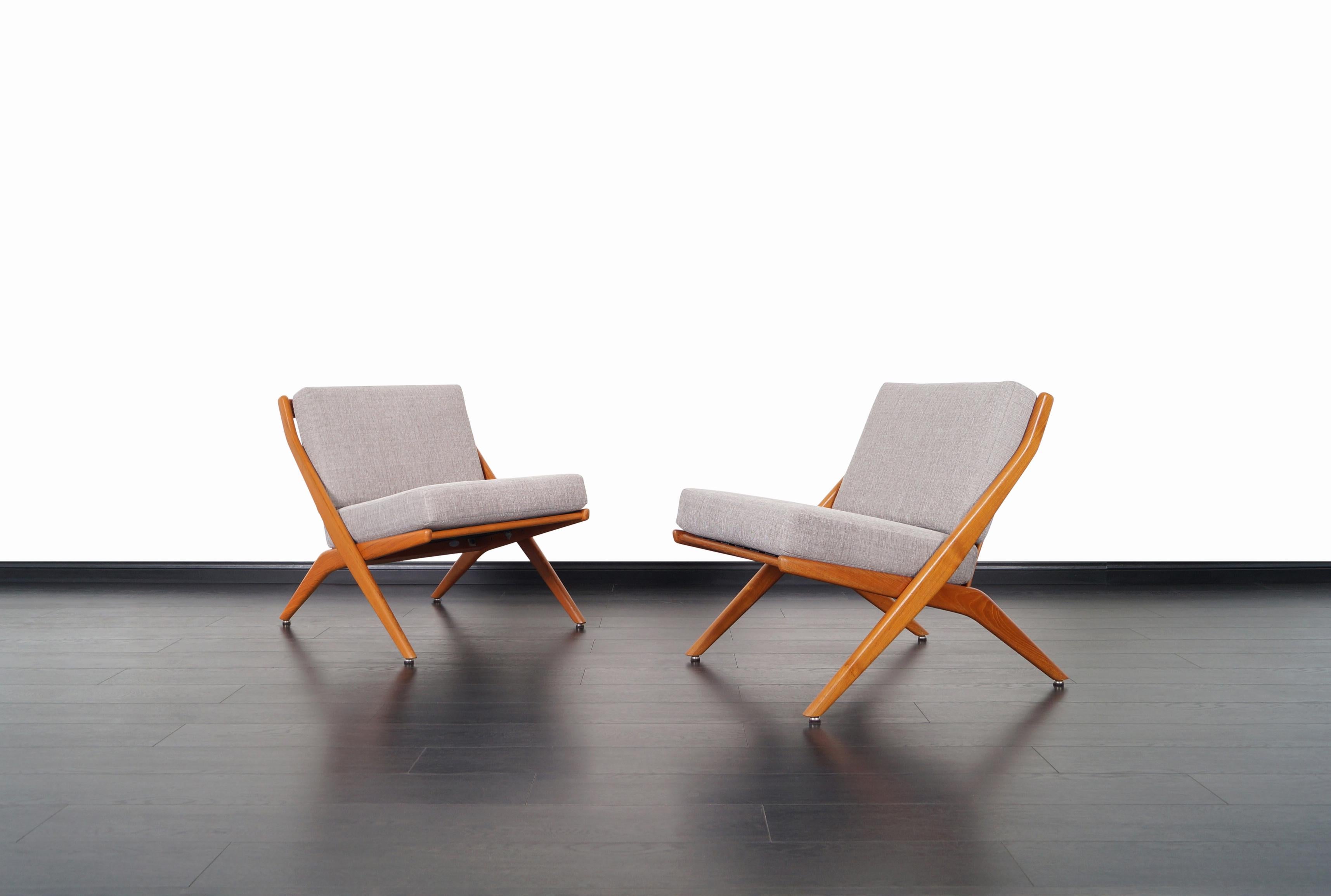 A stunning pair of vintage lounge chairs designed by Folke Ohlsson for Dux of Sweden, circa 1950s. These elegant Scandinavian design chairs feature a 