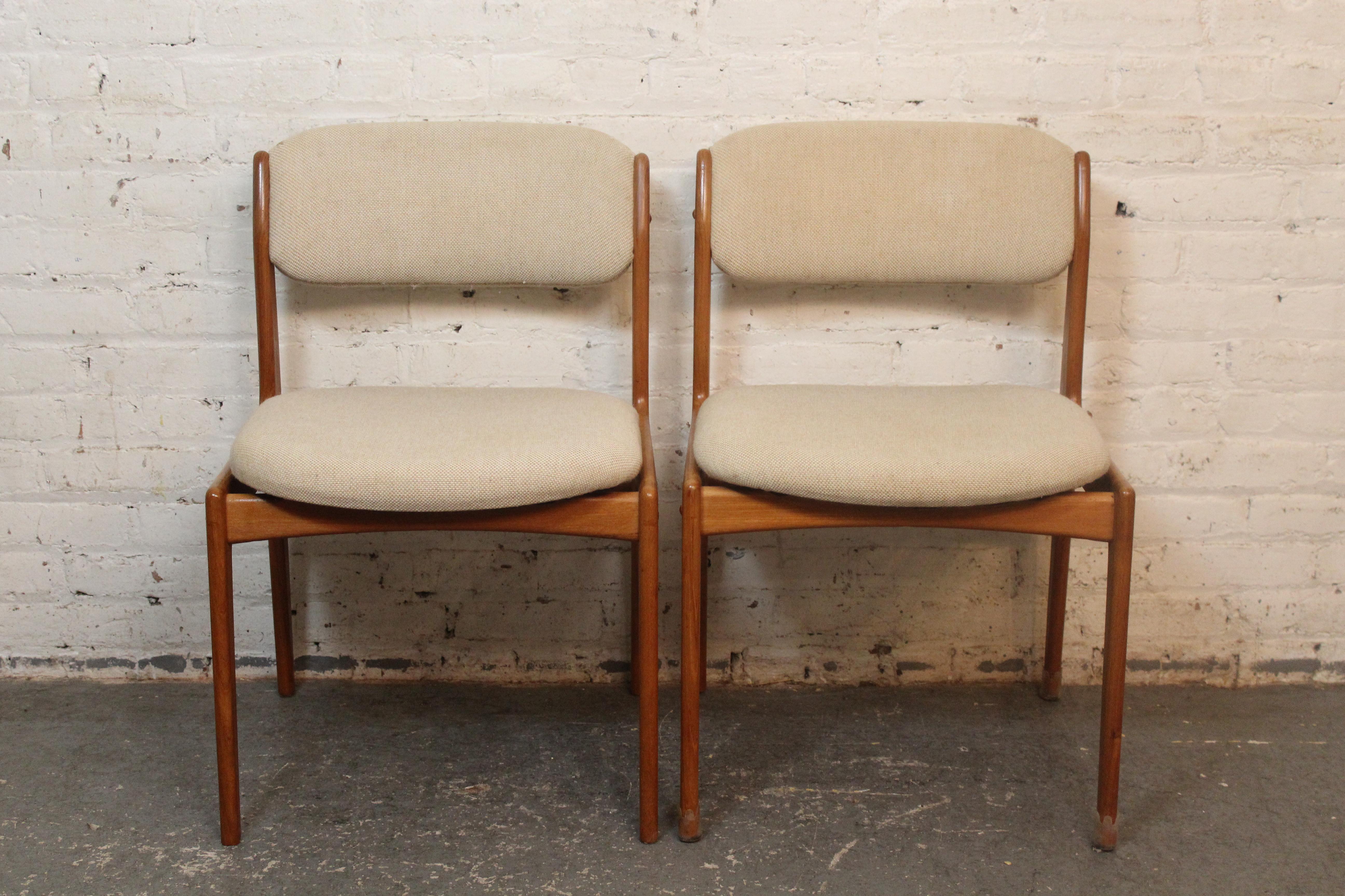 Bring home classic Scandinavian Modern with this pair of teak side chairs designed by Benny Linden. Sporting sturdy solid wood frames and a cushioned seat and back upholstered in a creamy tweed fabric, this versatile duo is sure to provide comfort