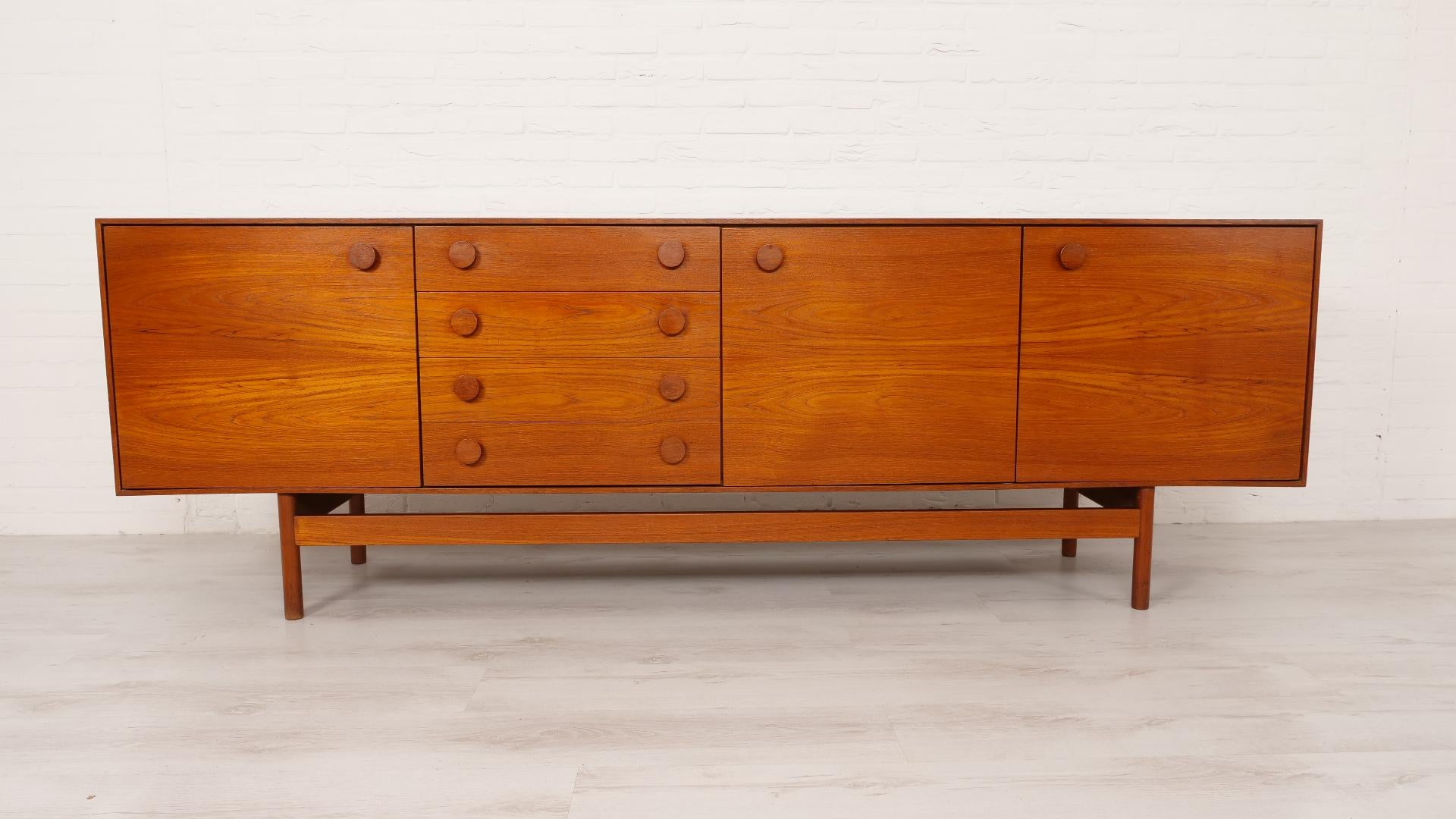 Insanely beautiful vintage sideboard designed by Ib Kofod-Larsen for Faarup Møbelfabrik in the 1960s. The vintage cabinet has a warm colour of wood and very nice round handles that are characteristic of Ib Kofod-Larsen's designs. The base completes