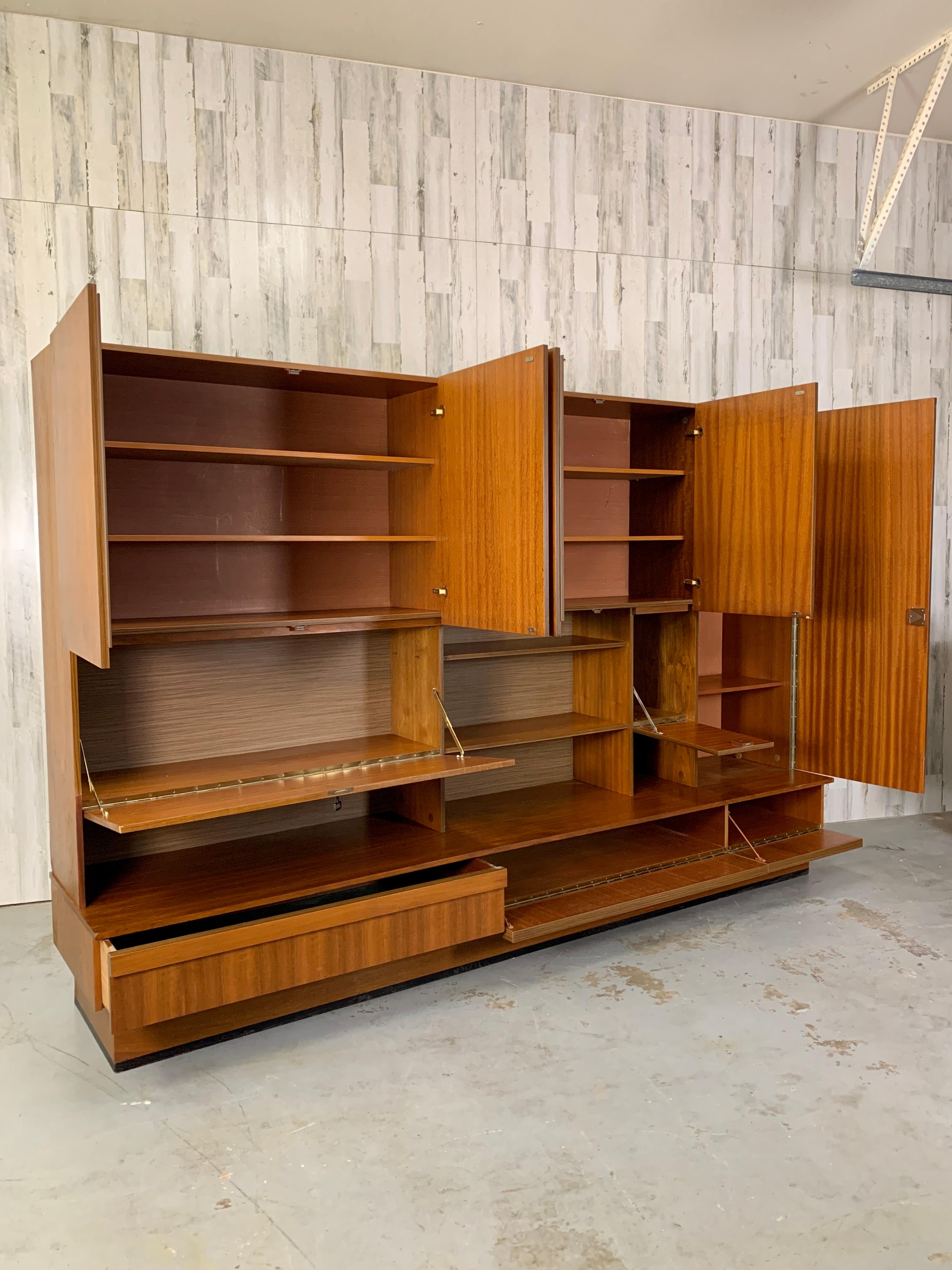 Large Mid-Century Modern German wall unit with multiple compartments and shelving. Base has pull down doors as well as one drawer. Contains 3 locked compartments of varying size. Would make a great bar cabinet or entertainment center.