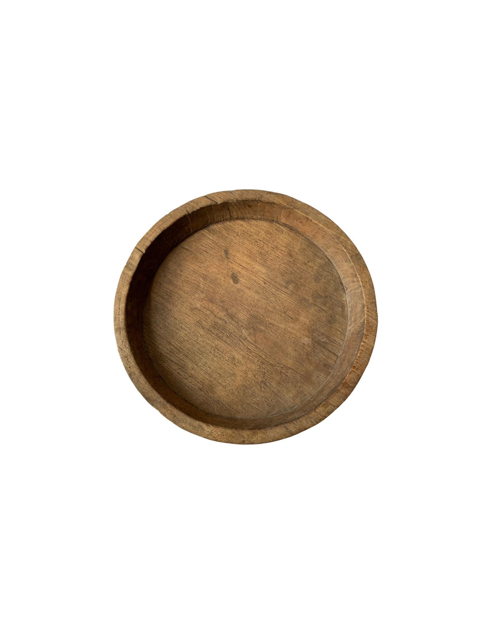 A teak wood bowl crafted on the island of Java, Indonesia. The bowl was cut from a much larger slab of wood and maintains a minimalist design. 

