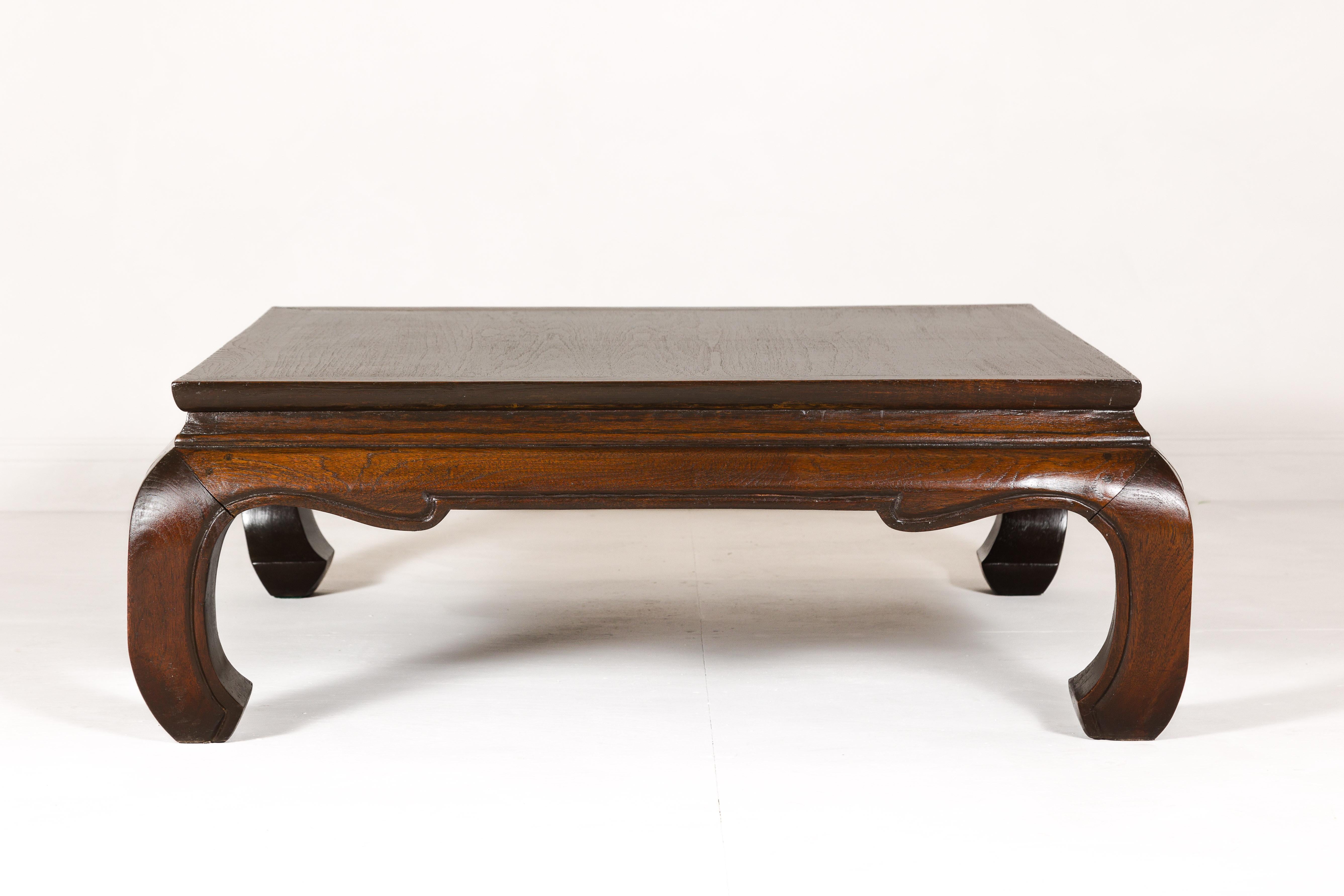 A vintage teak wood coffee table with chow legs and brown oil finish. This vintage teak wood coffee table embodies a fusion of understated elegance and sturdy functionality, perfect for anchoring a living space with its timeless appeal. Crafted with
