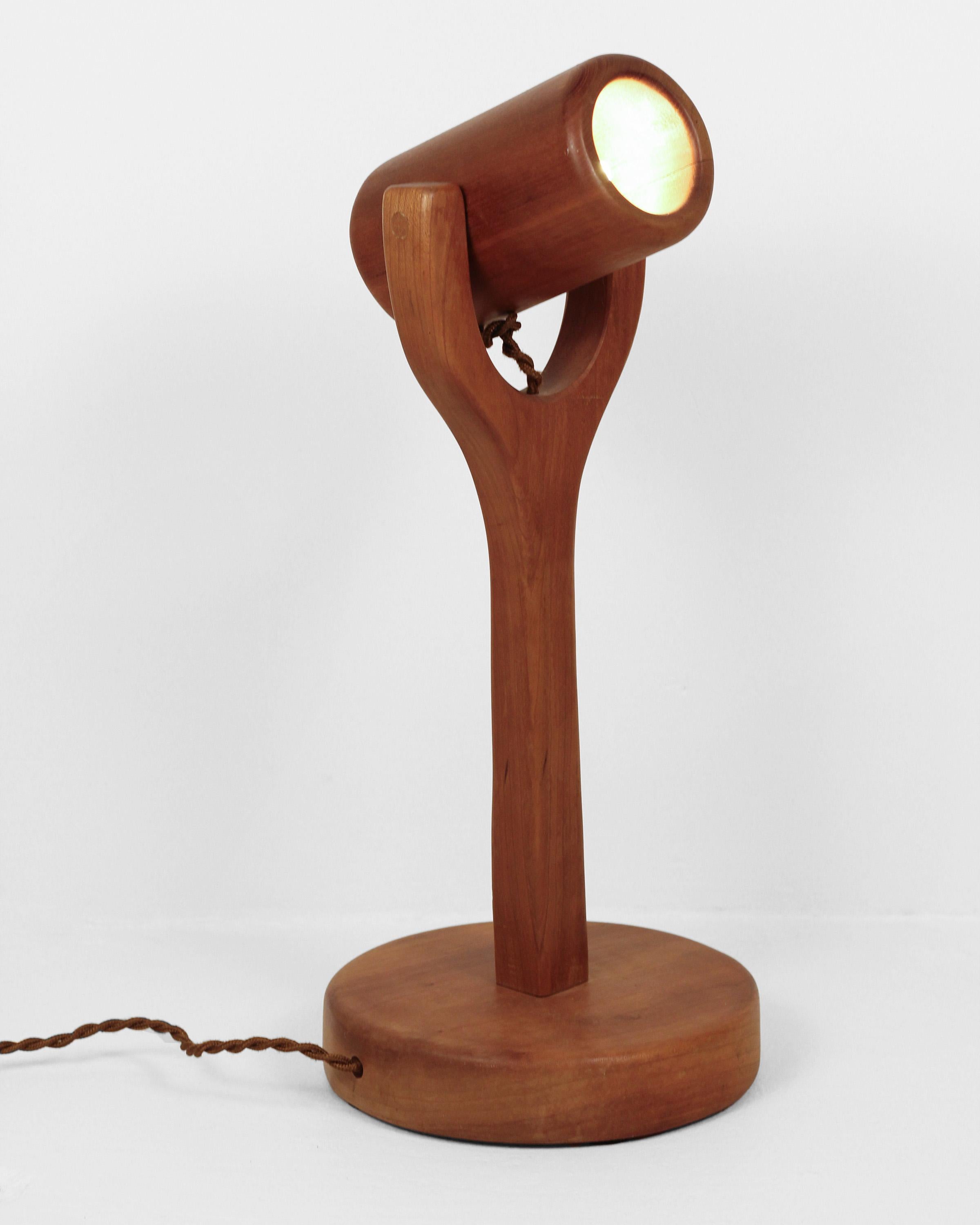 A playful and eclectic handmade table lamp with a beautiful, smooth, teak wood finish. A truly unique lamp that adds a touch of fun '70s style while also being highly functional. The teak wood table lamp easily adjusts to whatever angle is needed,