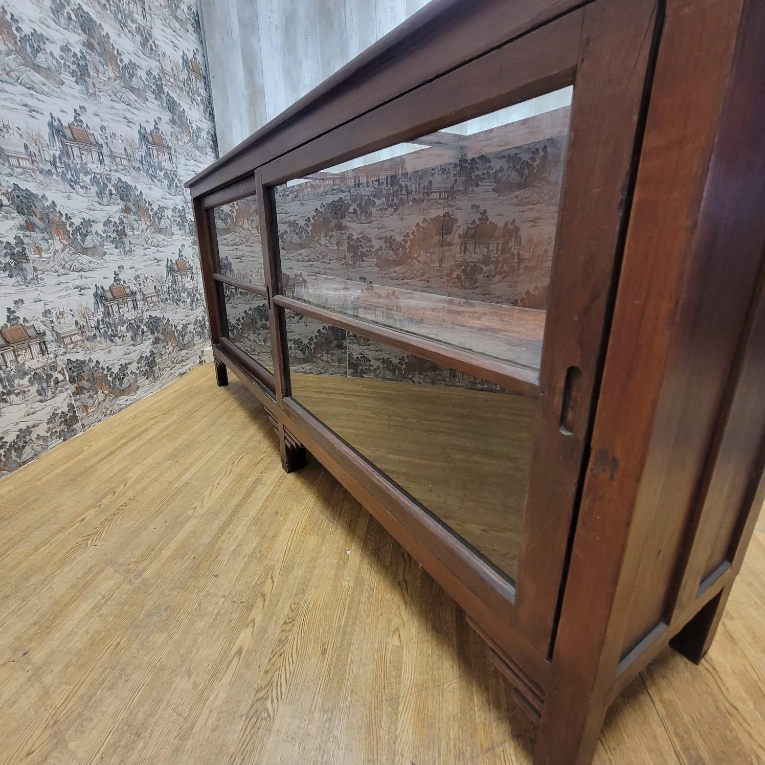 Colonial britannique Bibliothèque/meuble de rangement bas vintage en teck avec portes en verre coulissantes en vente