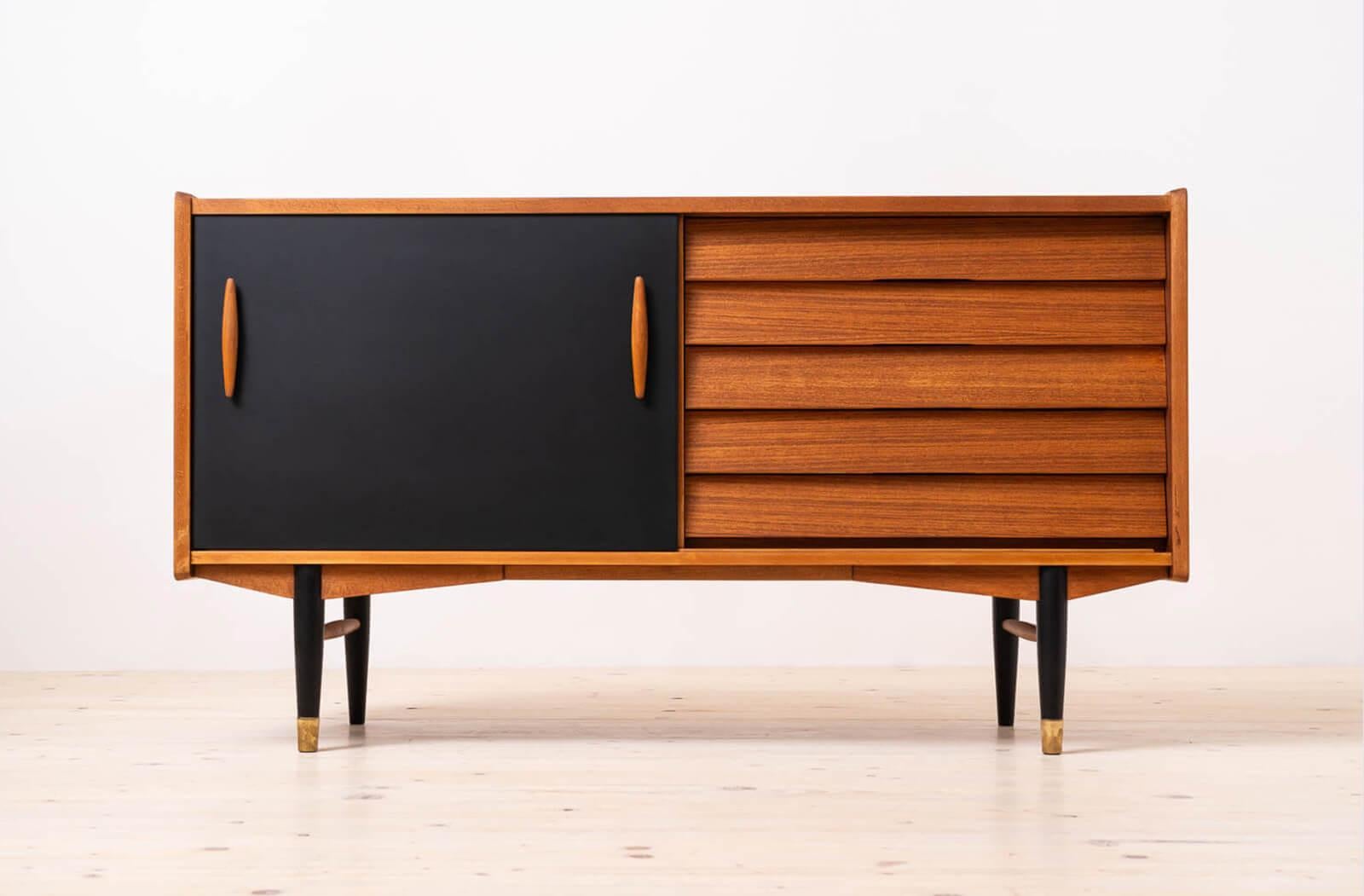 Discover the rare elegance of this distinctive teak wood sideboard, a unique design by Nils Jonsson exemplifying the timeless allure of Scandinavian Modern style. Crafted with precision and attention to detail, this remarkable piece features black