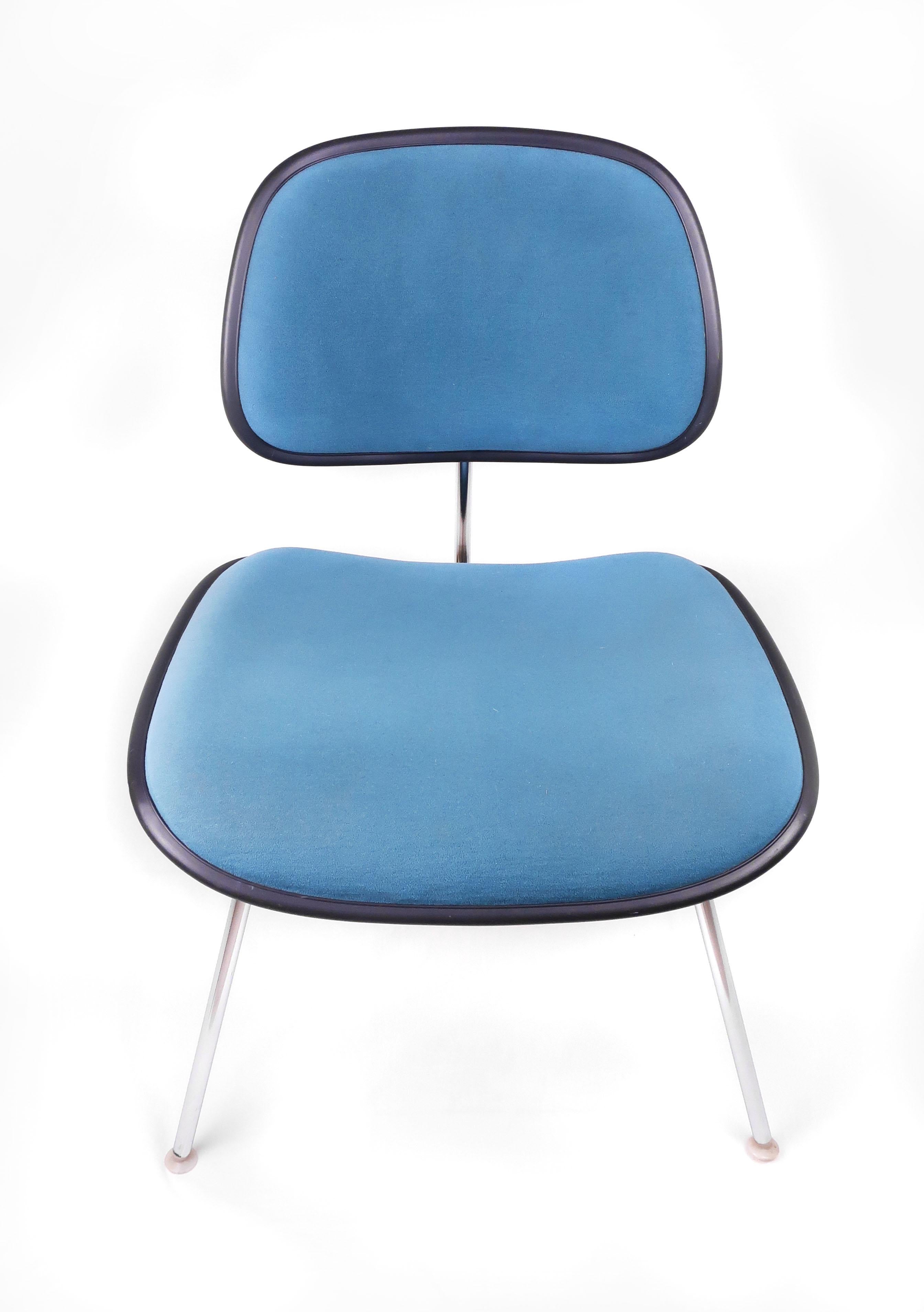 A vintage upholstered EC-127 DCM chairs by Ray and Charles Eames for Herman Miller. Molded plastic seats and backs with a lovely teal upholstery, black piping around the seat and back, chrome legs, and original Herman Miller label on underside. Very