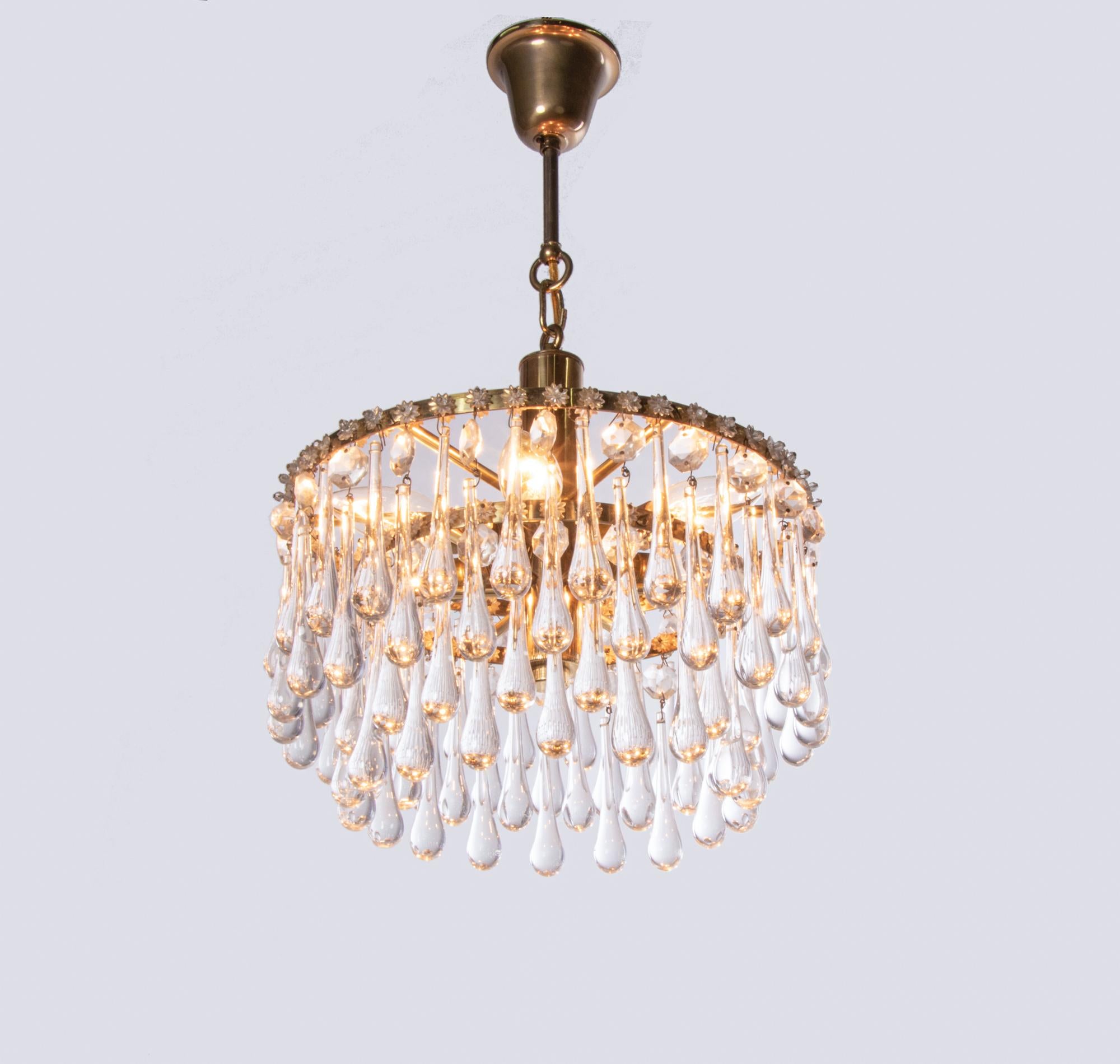 Beautiful and elegant chandelier with teardrop crystals on a tiered brass base. 

Measures: diameter 13
