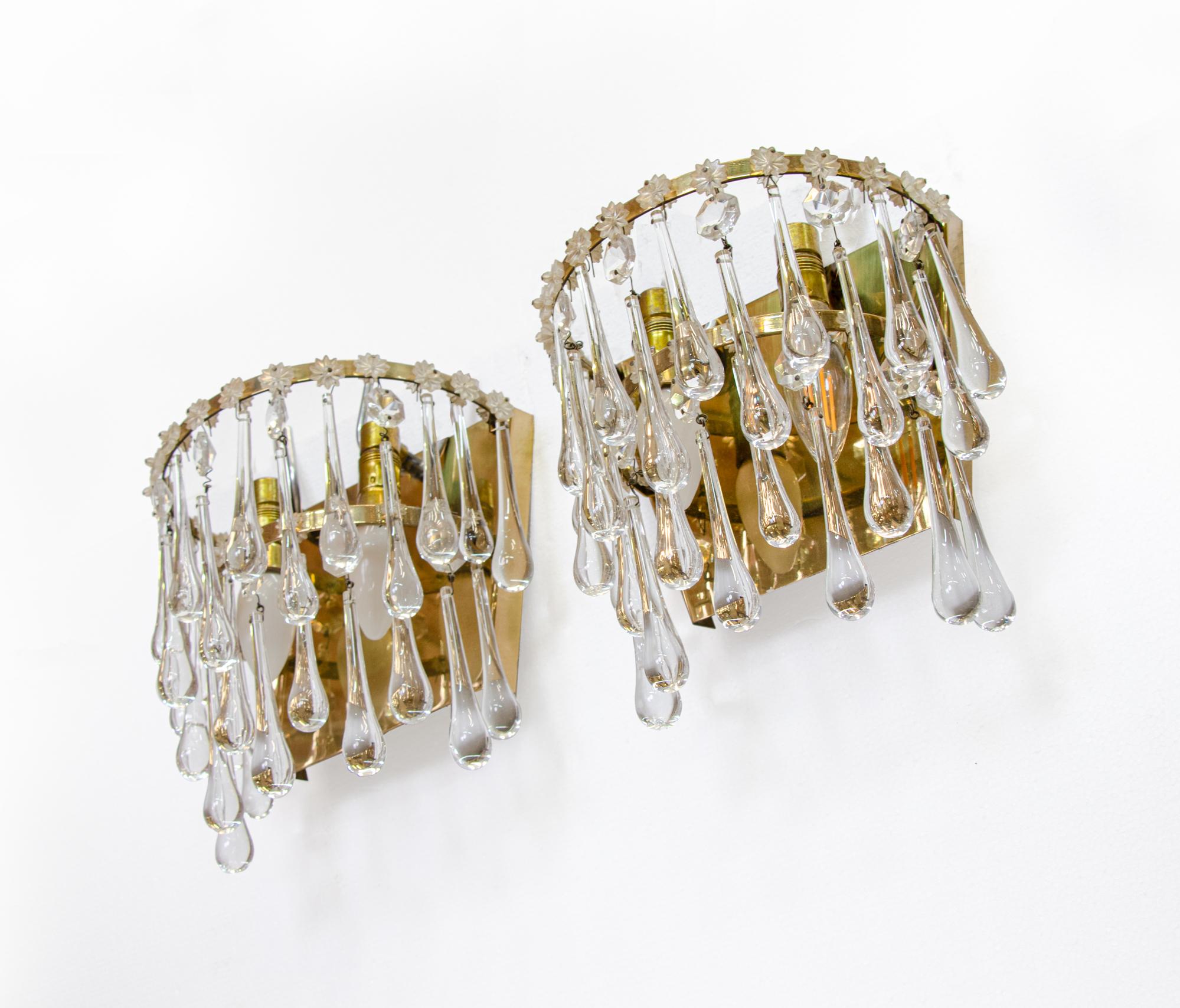 Elegant set of wall lights with teardrop crystals on a tiered brass base. 

Measures: width 9.5