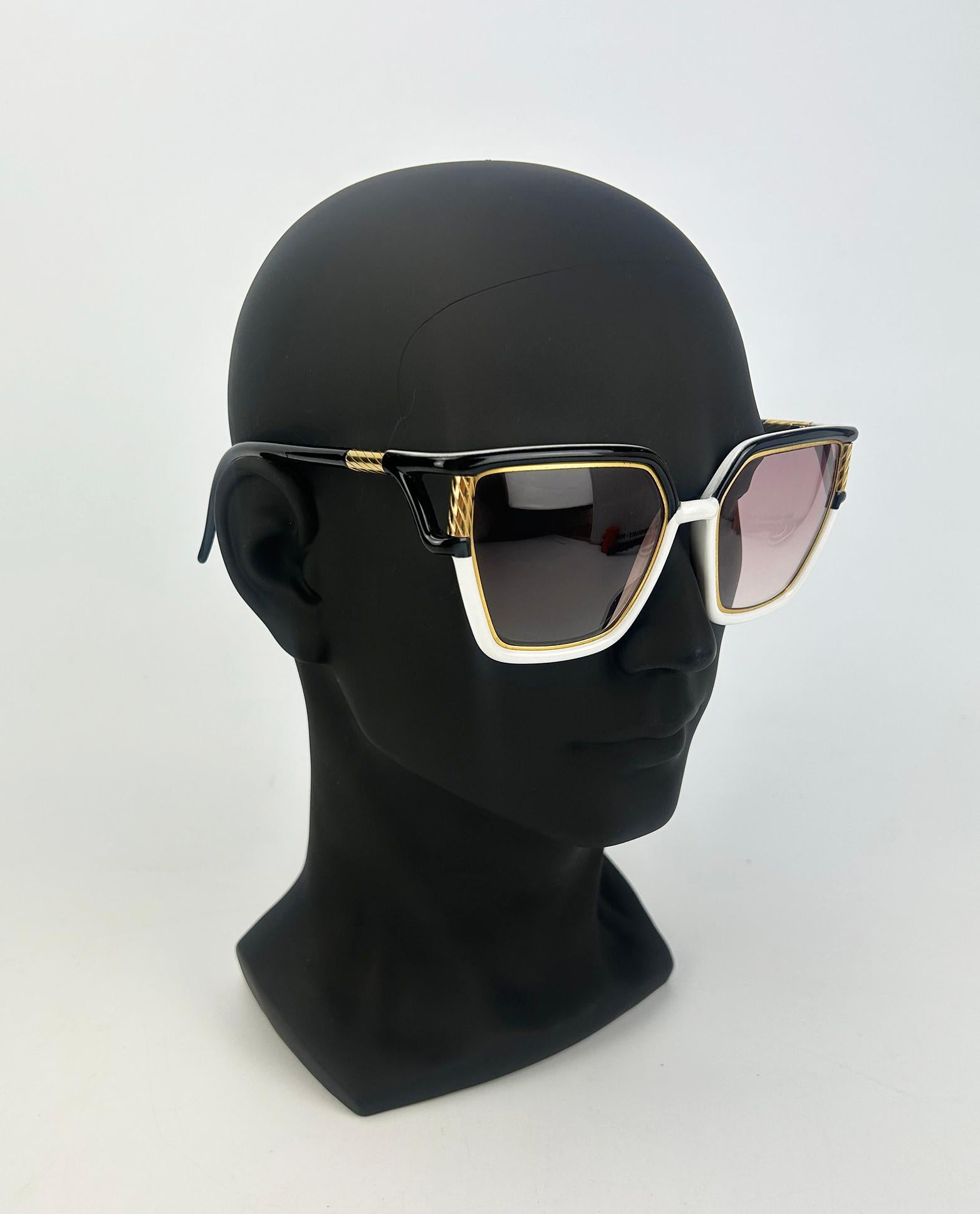 Vintage Ted Lapidus Black White and Gold Sunglasses c1970s in very good condition. Black arms and back of lenses, white front lens trimmed with gold hardware throughout and around inside edge of lenses. Light brown gradient lenses. Overall very good
