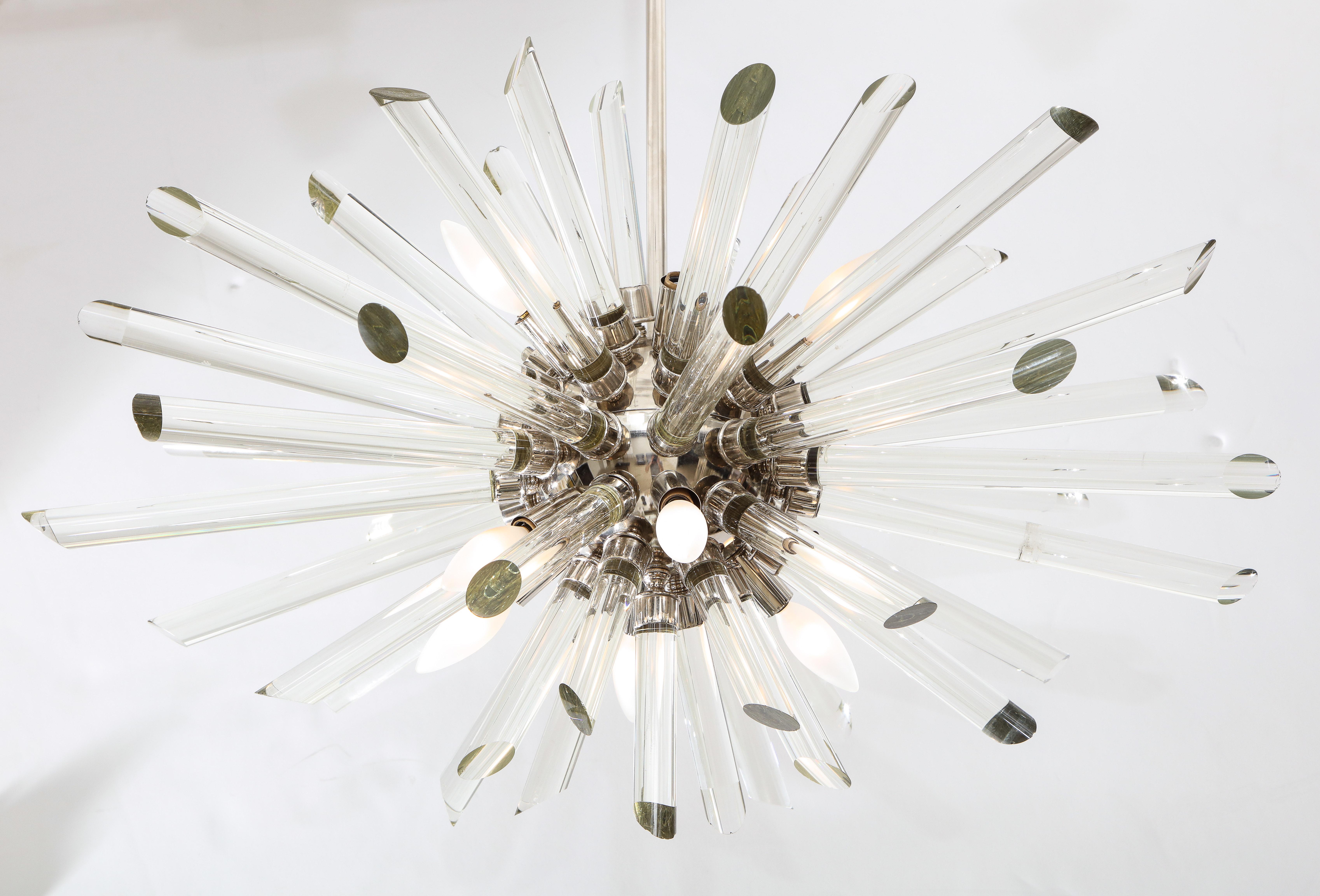 A ten light Sputnik chandelier with numerous glass rods hangs from a nickel-plated central pole that can be adjusted to ceiling height.