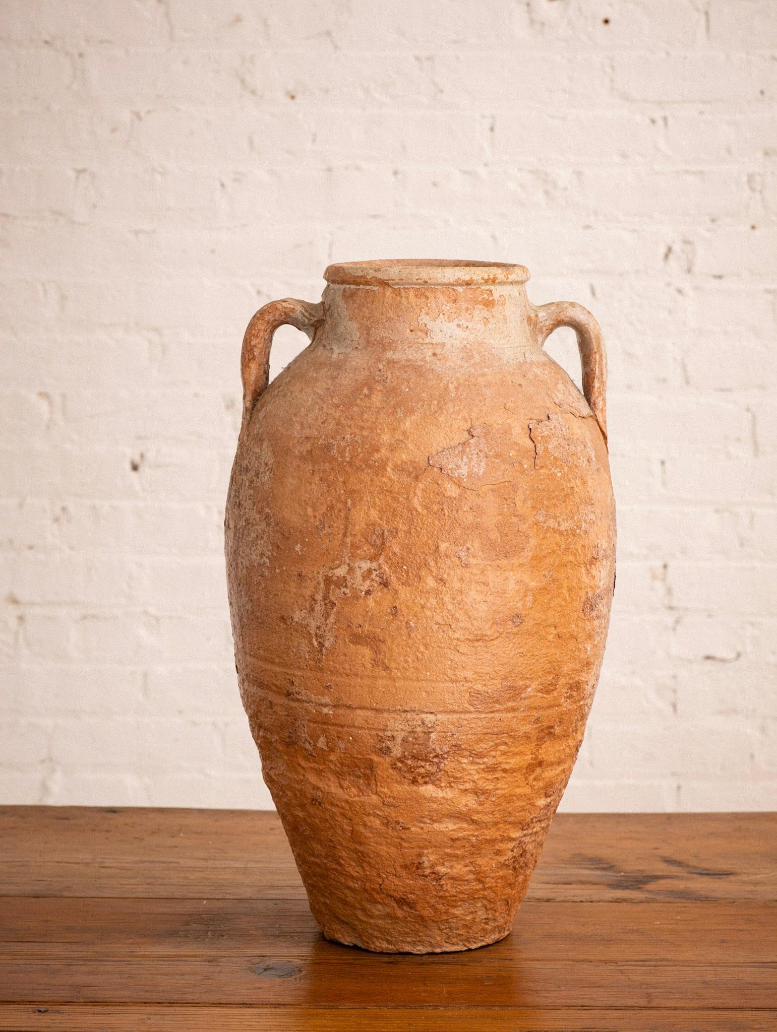 A mid-sized hand thrown terra cotta vessel with iridescent finish. Classic amphora shape.
