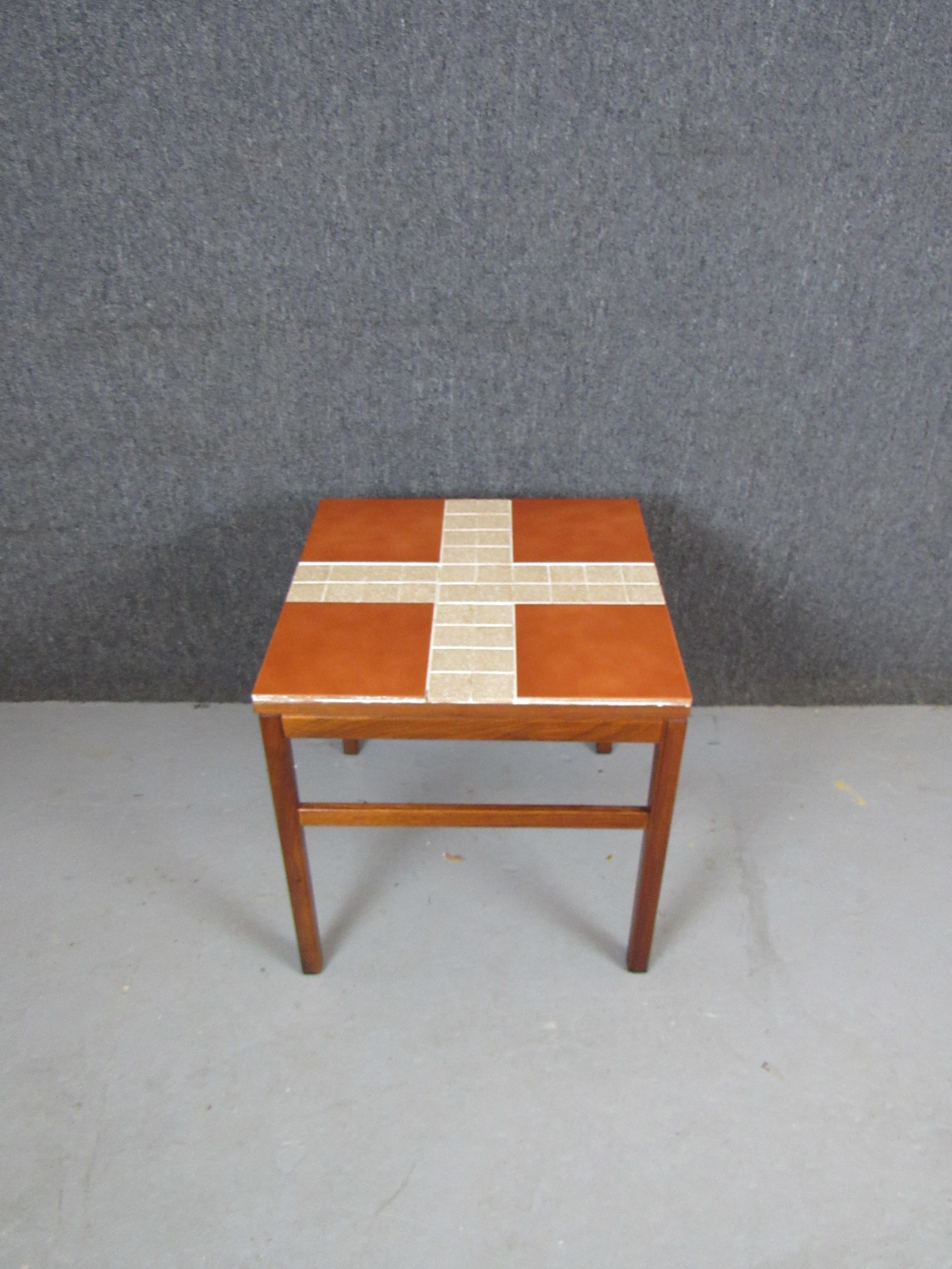 Wonderfully unique side table with a terracotta tiled top on a teak frame. Made by New York's Arbatove and borrowing readily from contemporary mid-century Danish design, this petite table is perfect for a myriad of uses, whether in the home or