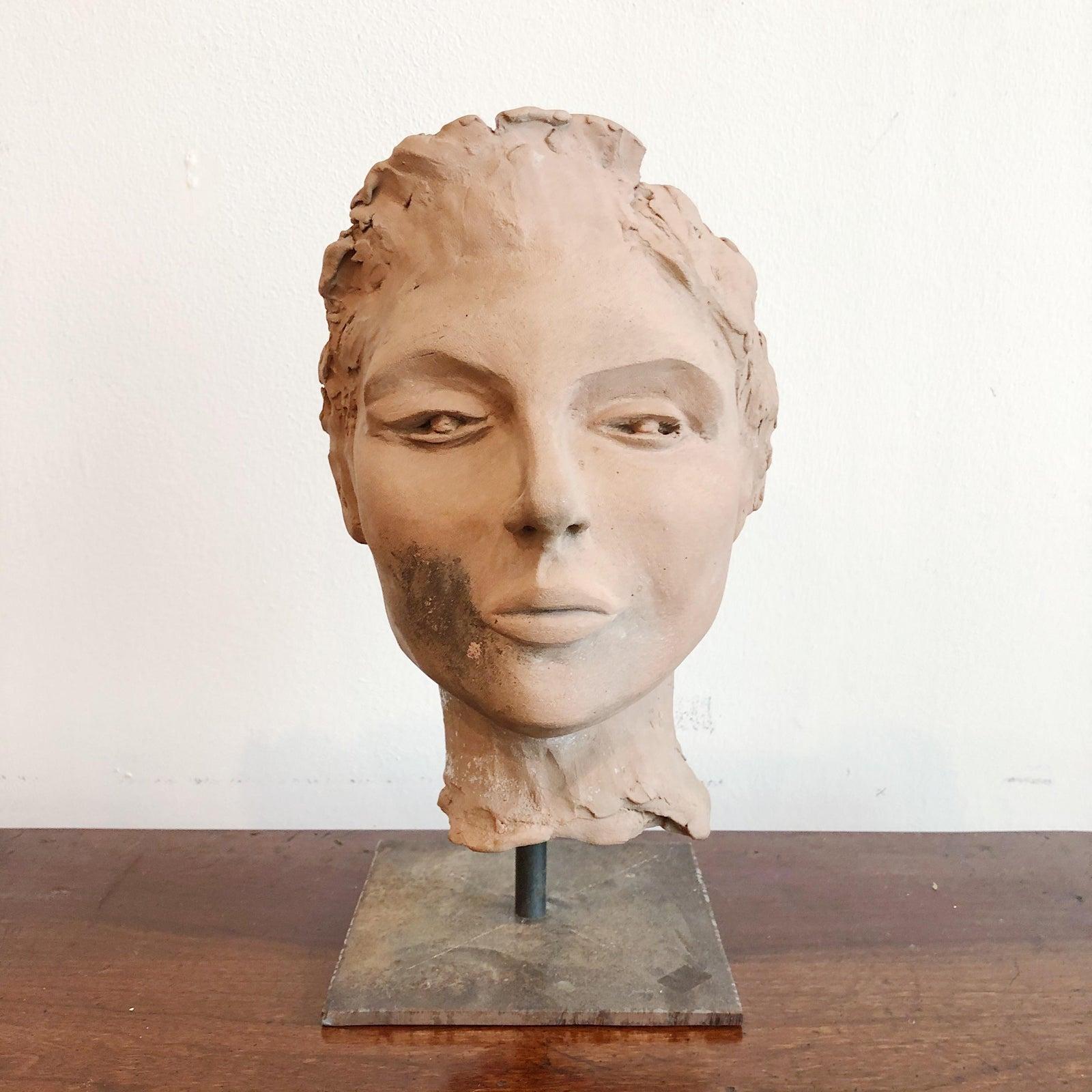 Vintage terra cotta sculpture, pensive in expression, supported by a custom iron base. Unsigned.