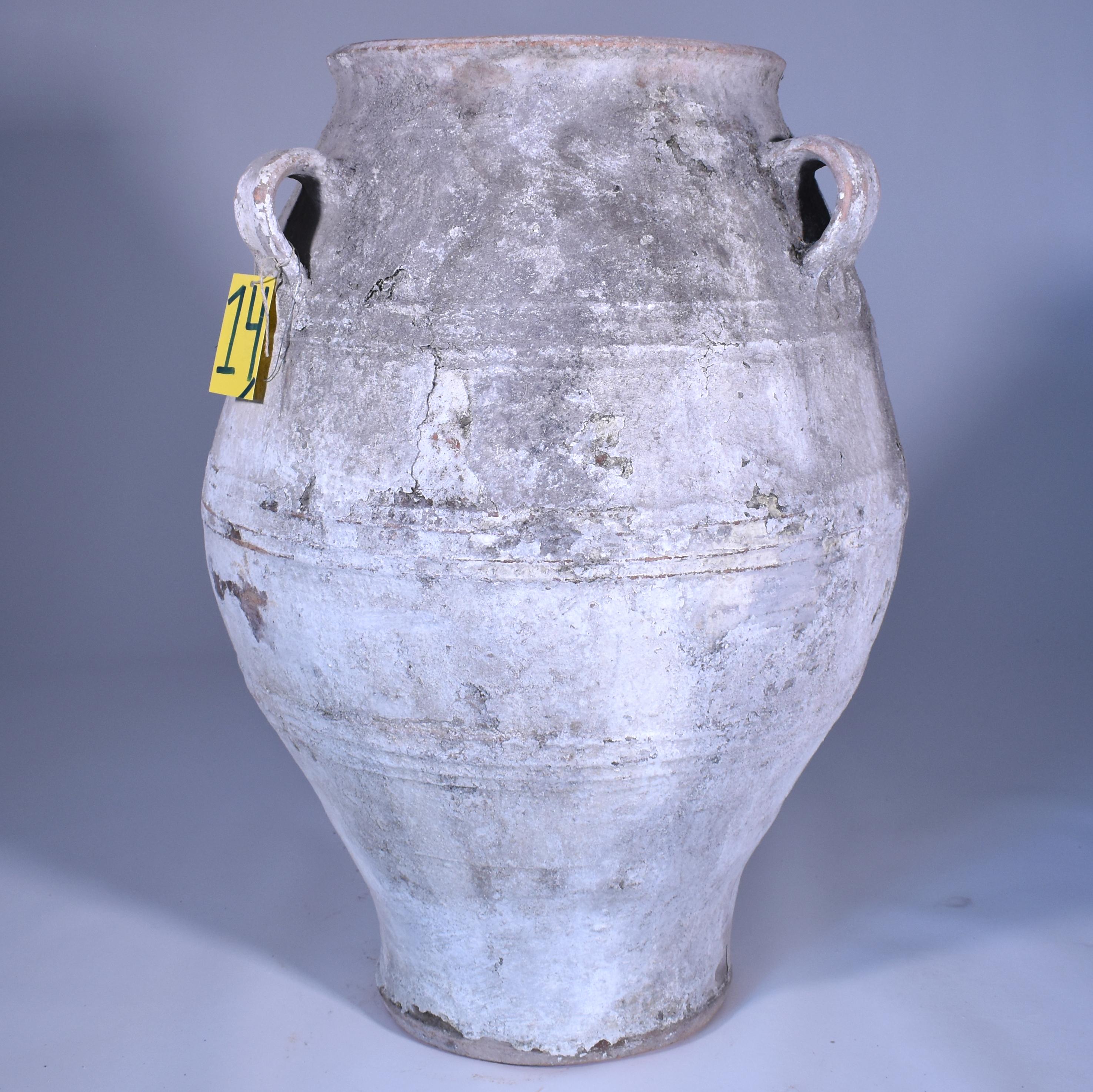 Large three-handled terracotta urn with white finish and gentle shape. I find these scattered across the elegant exteriors of homes in Southern France and Italy and use them in my own yard in New Orleans. The graceful silhouette and chalky white