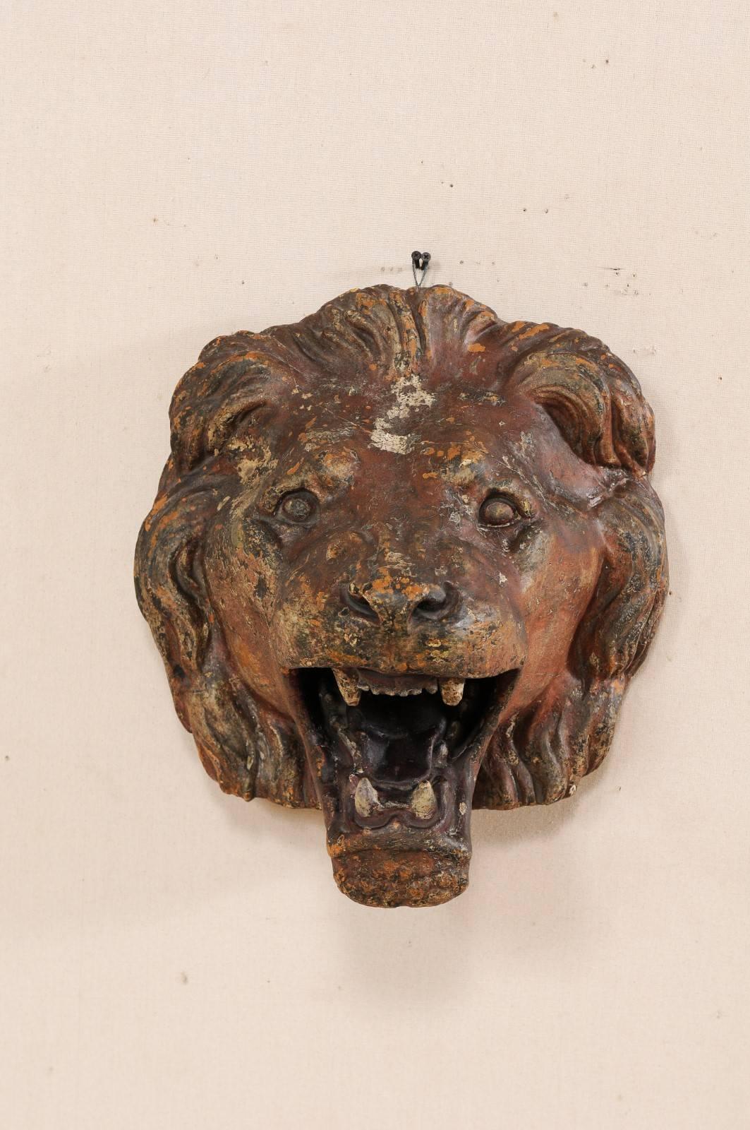 A terracotta lion head wall-mounted decoration. This vintage terracotta lion, attributed to have originated out of The Ringling Bros. and Barnum & Bailey Circus, Florida, USA. This African lion is featured with a wrapped head of full bushy mane,